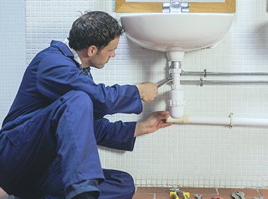 Man repairing bathroom sink -  Drain cleaning in Lynn, MA