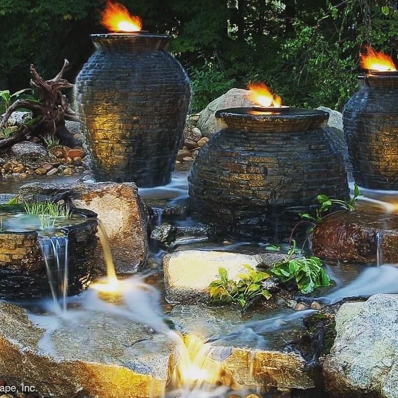 A small pond with a waterfall in the middle of it surrounded by rocks.