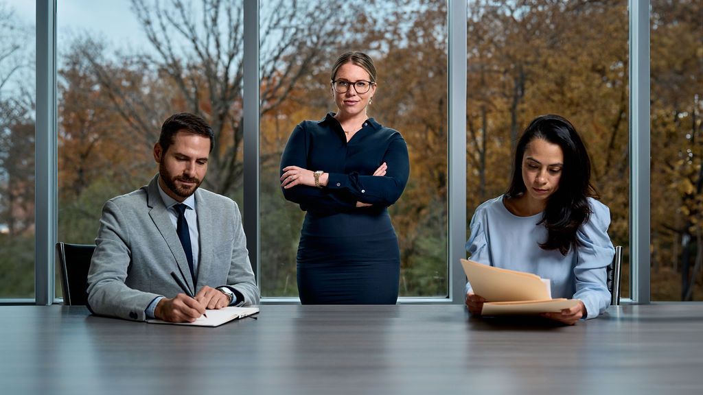 A woman is sitting at a desk with a judge 's gavel and scales of justice.