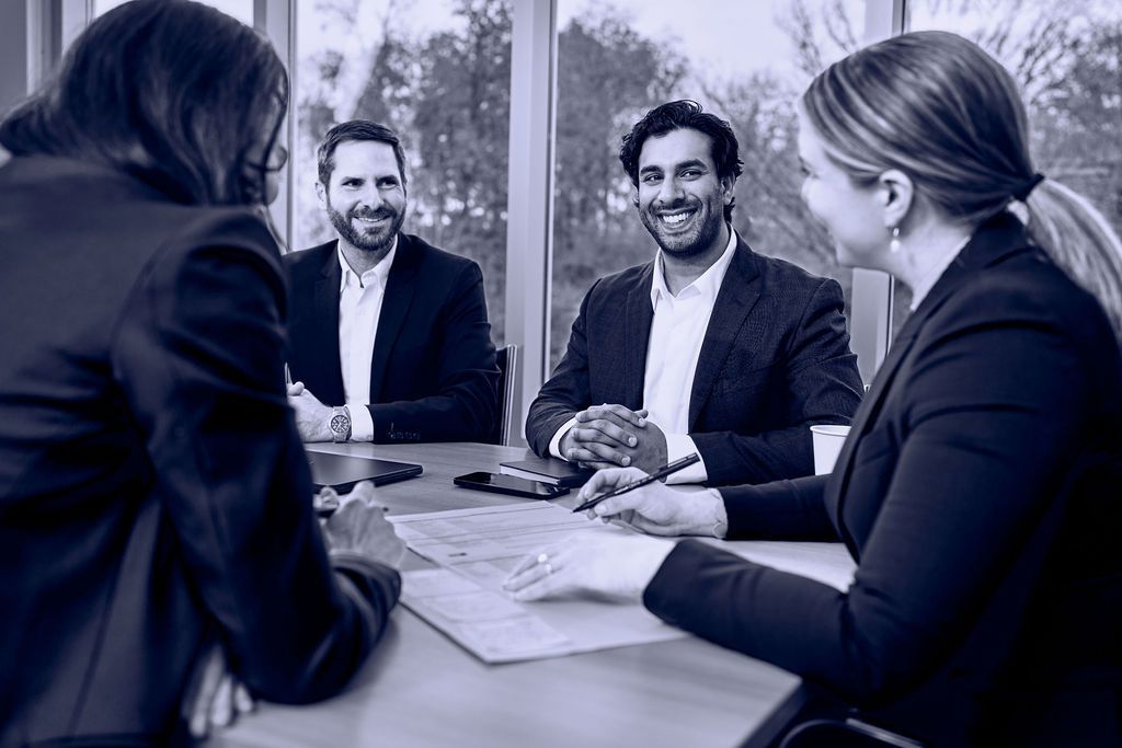 A group of people are sitting around a table having a meeting.