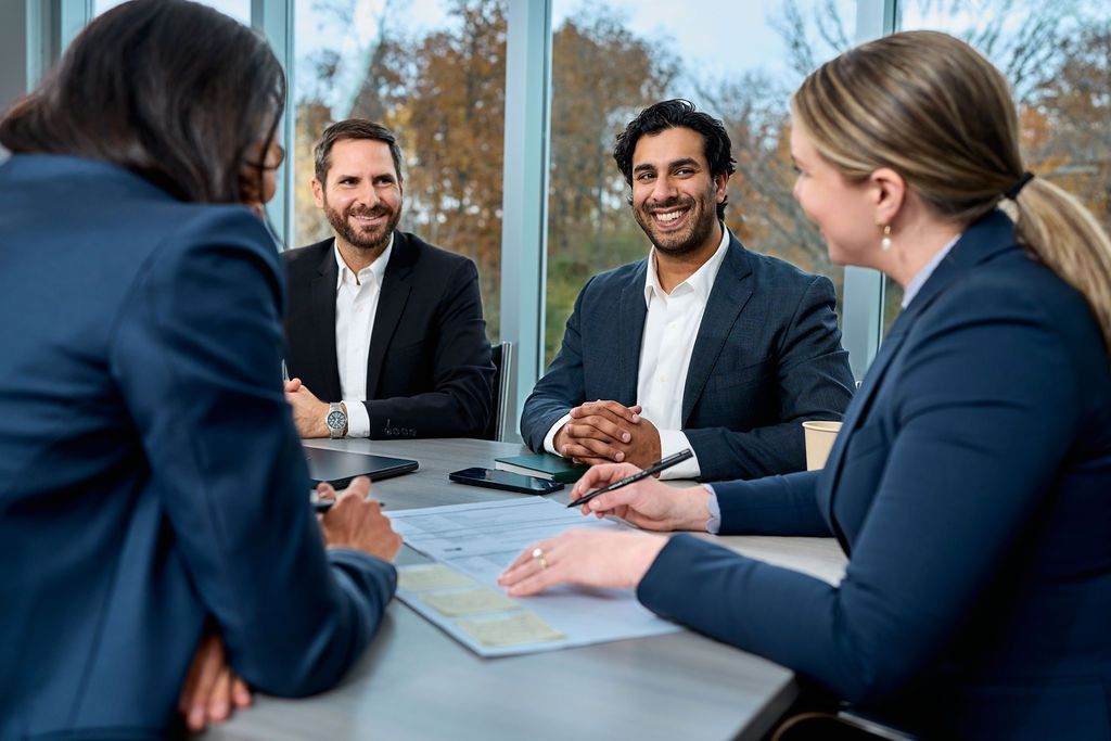 A group of people are sitting around a table having a meeting.