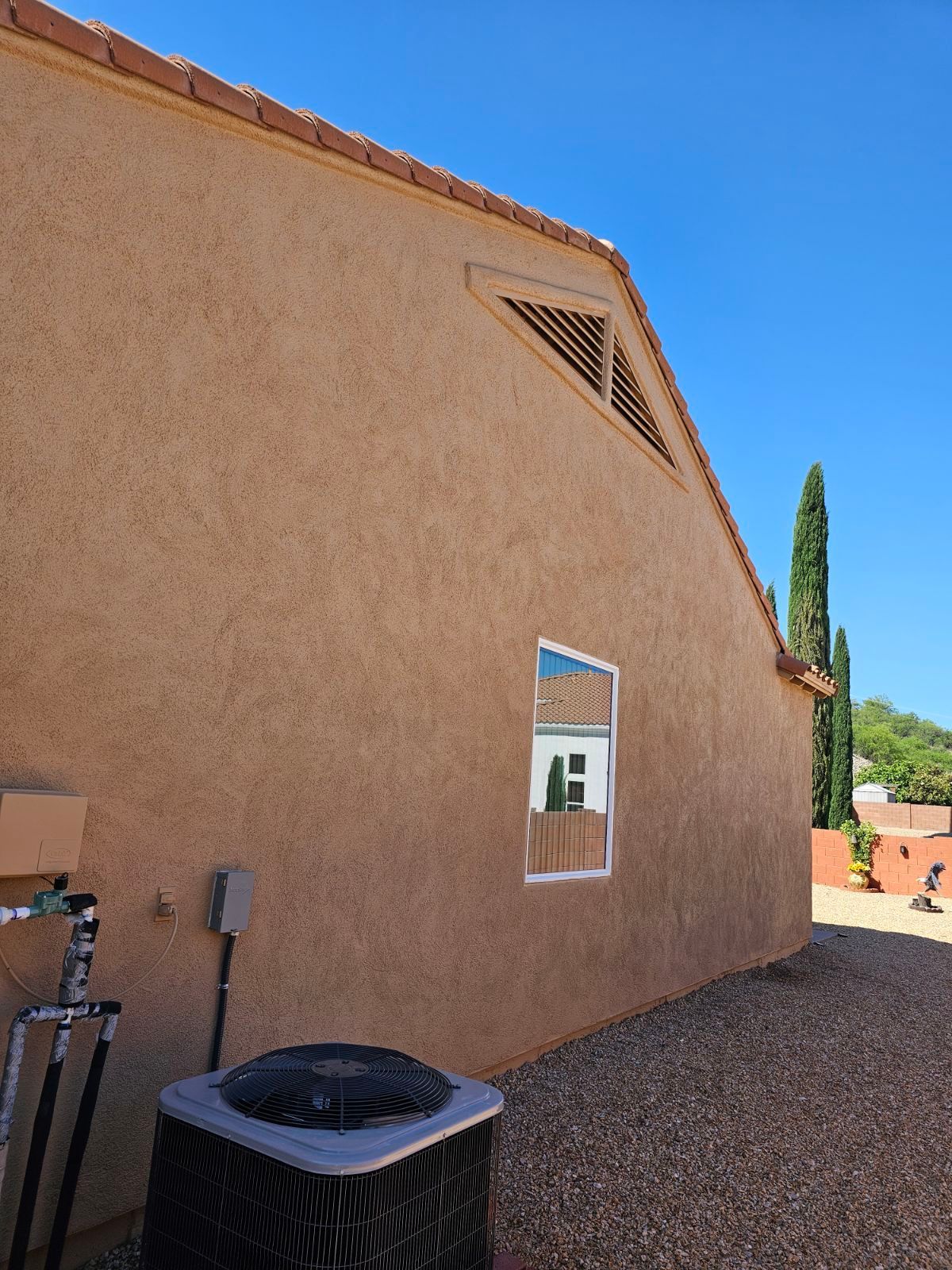 A house with a window and an air conditioner on the side
