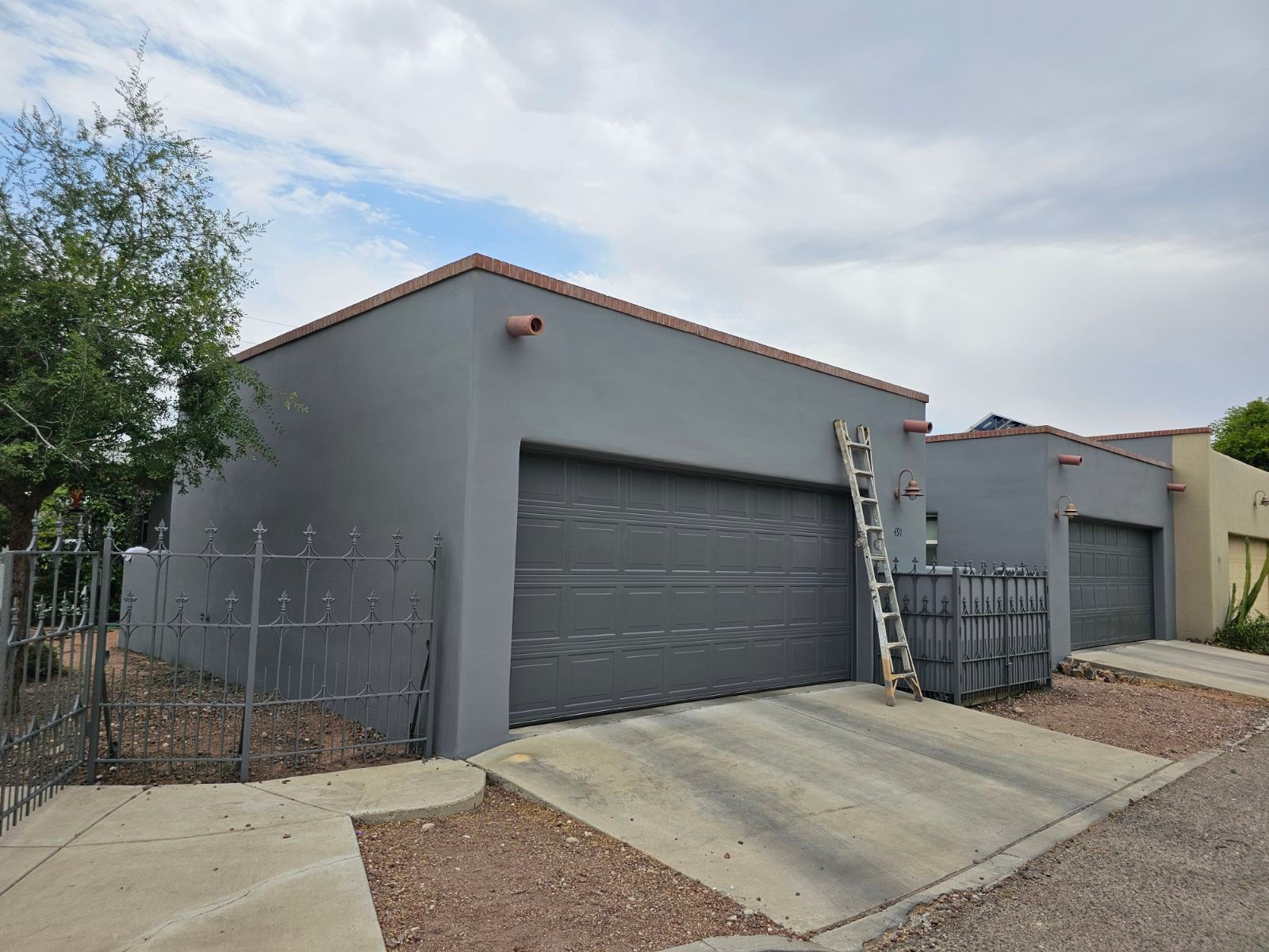 A house with two garage doors and a ladder on the side of it.
