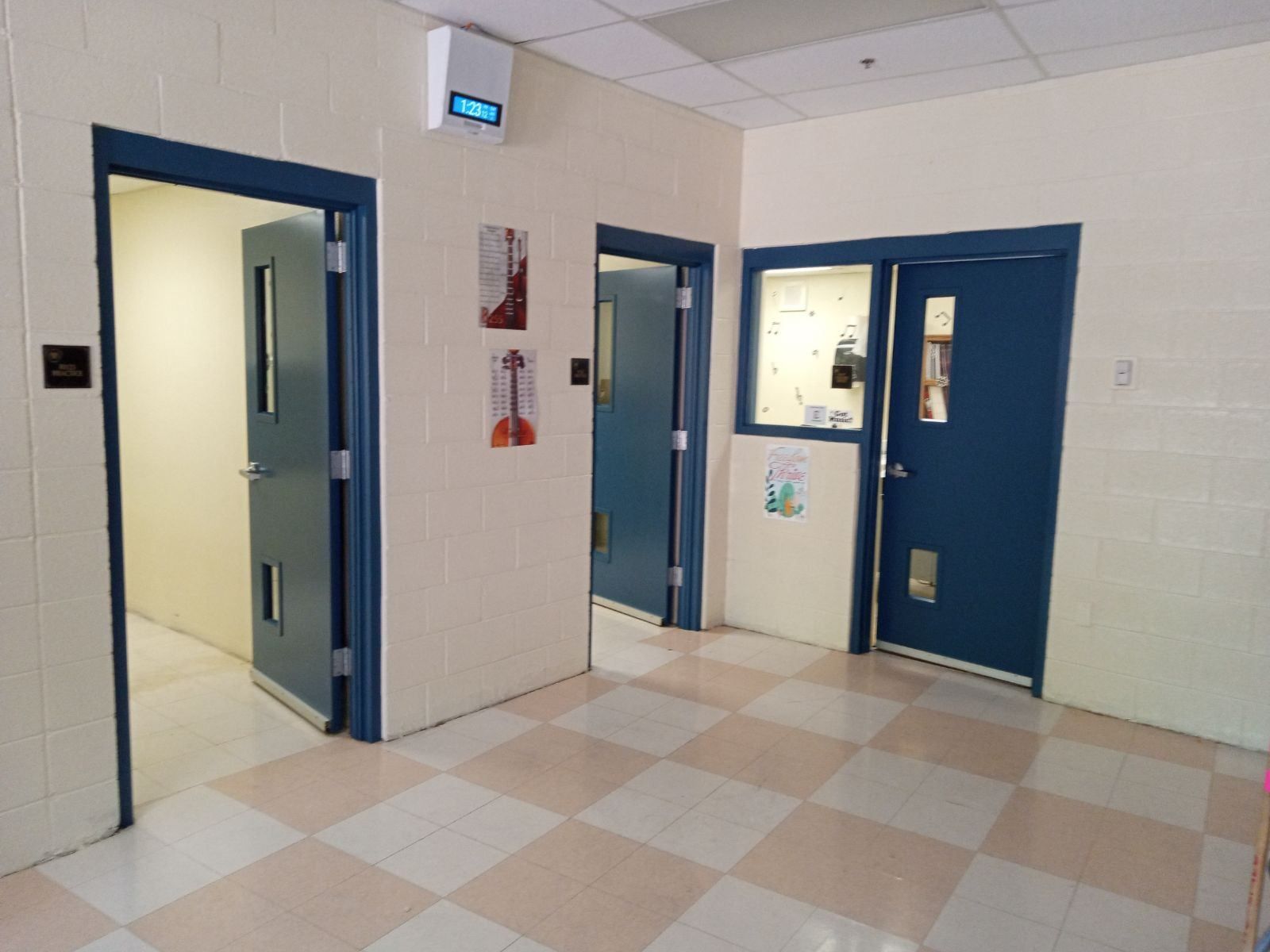 A hallway with blue doors and a checkered floor