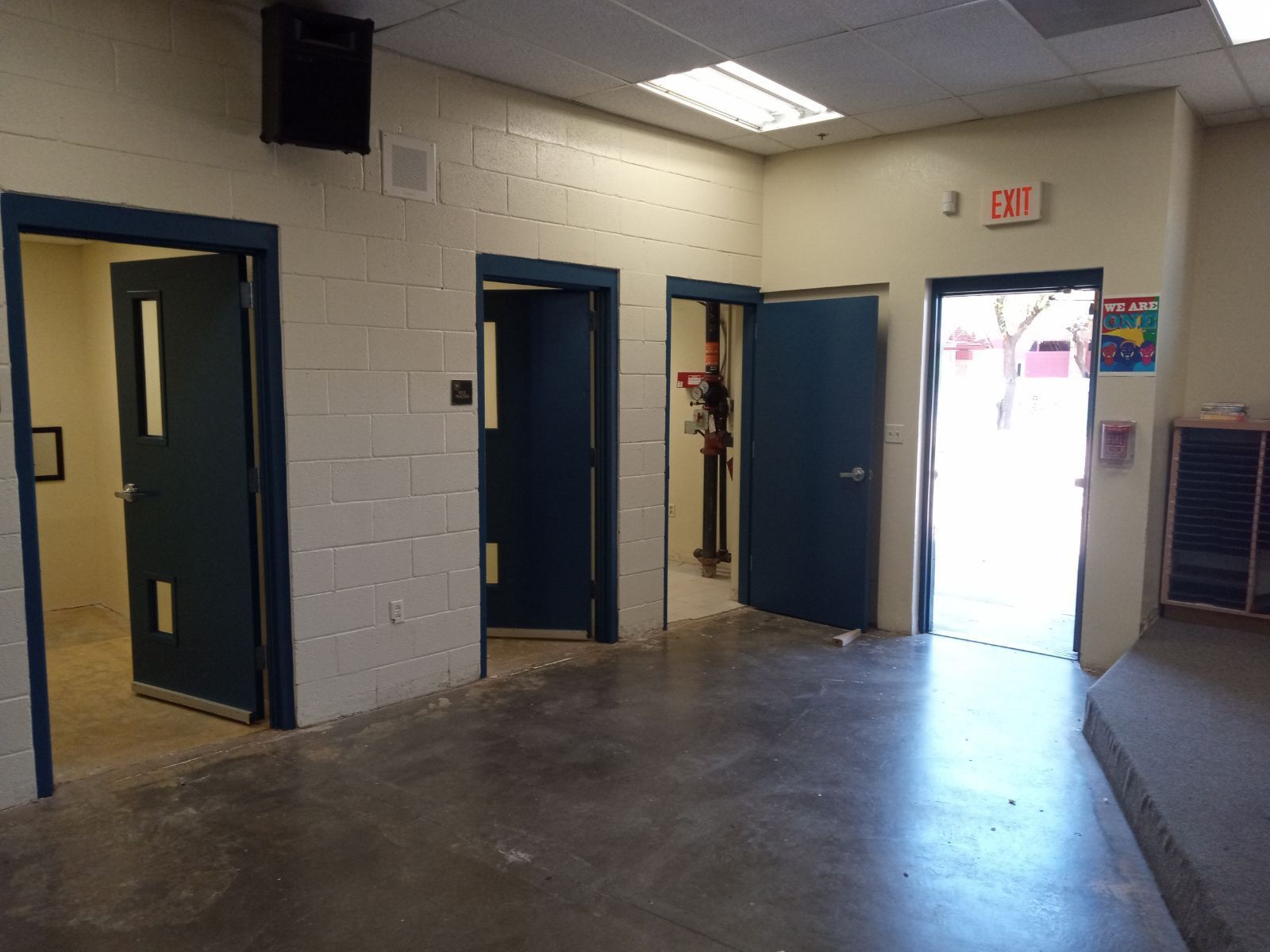 A room with a lot of doors and a sign that says exit