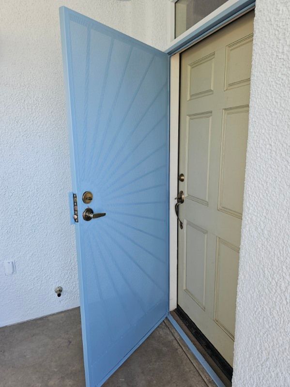 A blue door is open to a white door