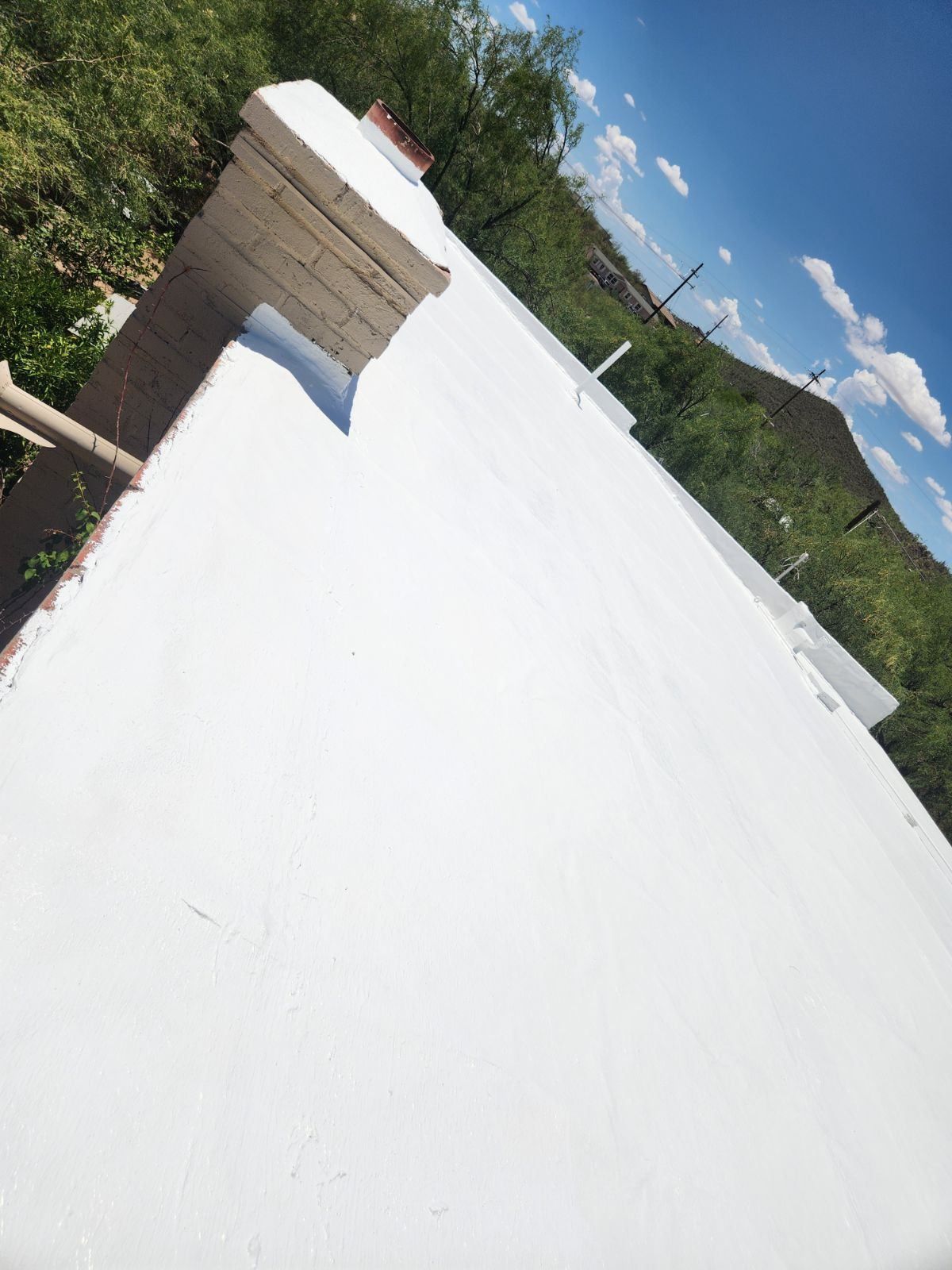 A white roof with a chimney on top of it.