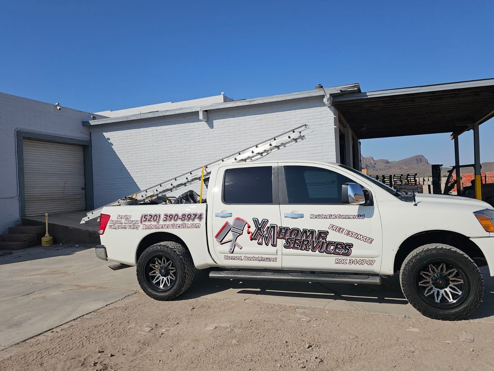 A white truck is parked in front of a building.