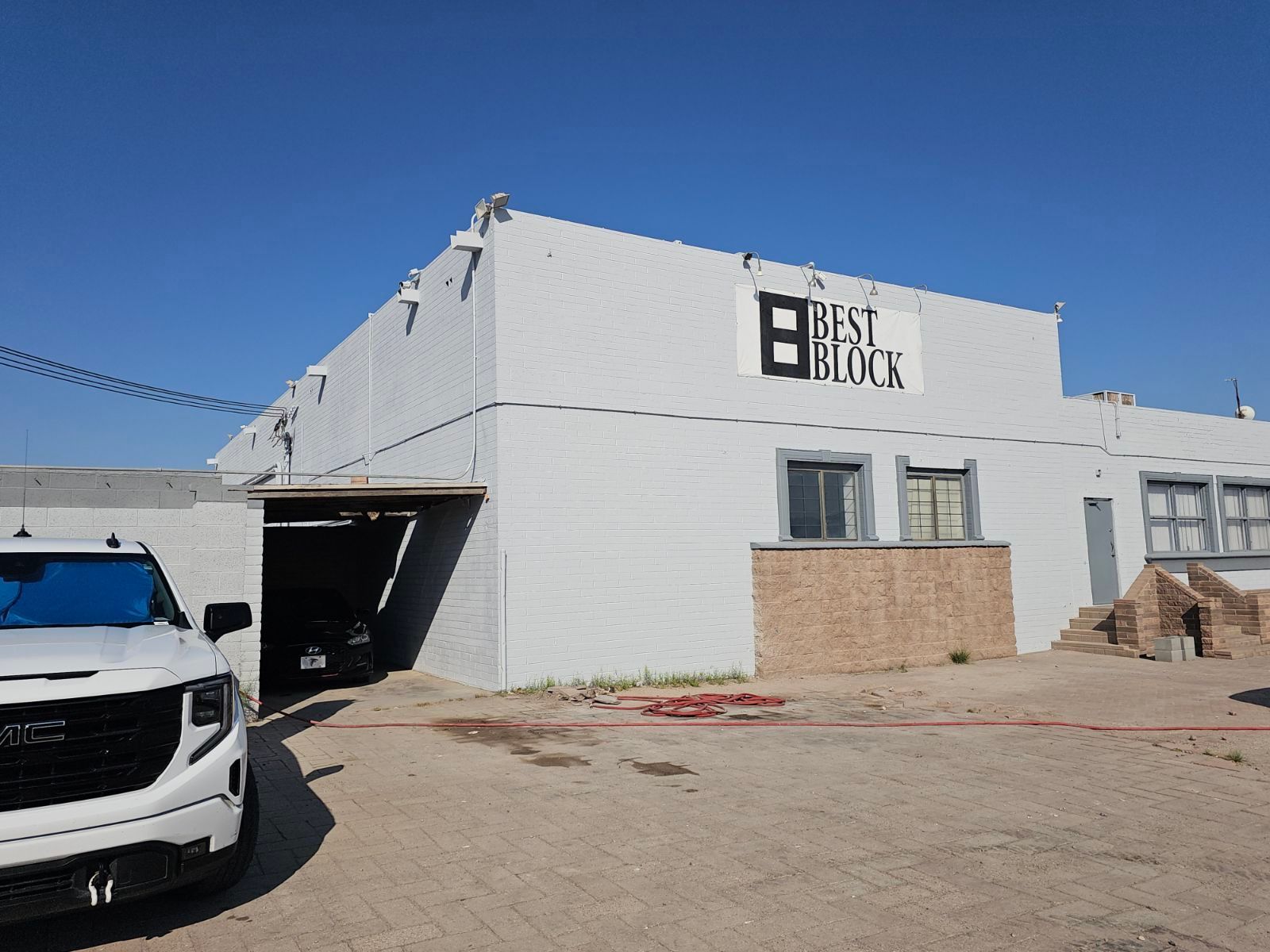 A white truck is parked in front of a building that says best block