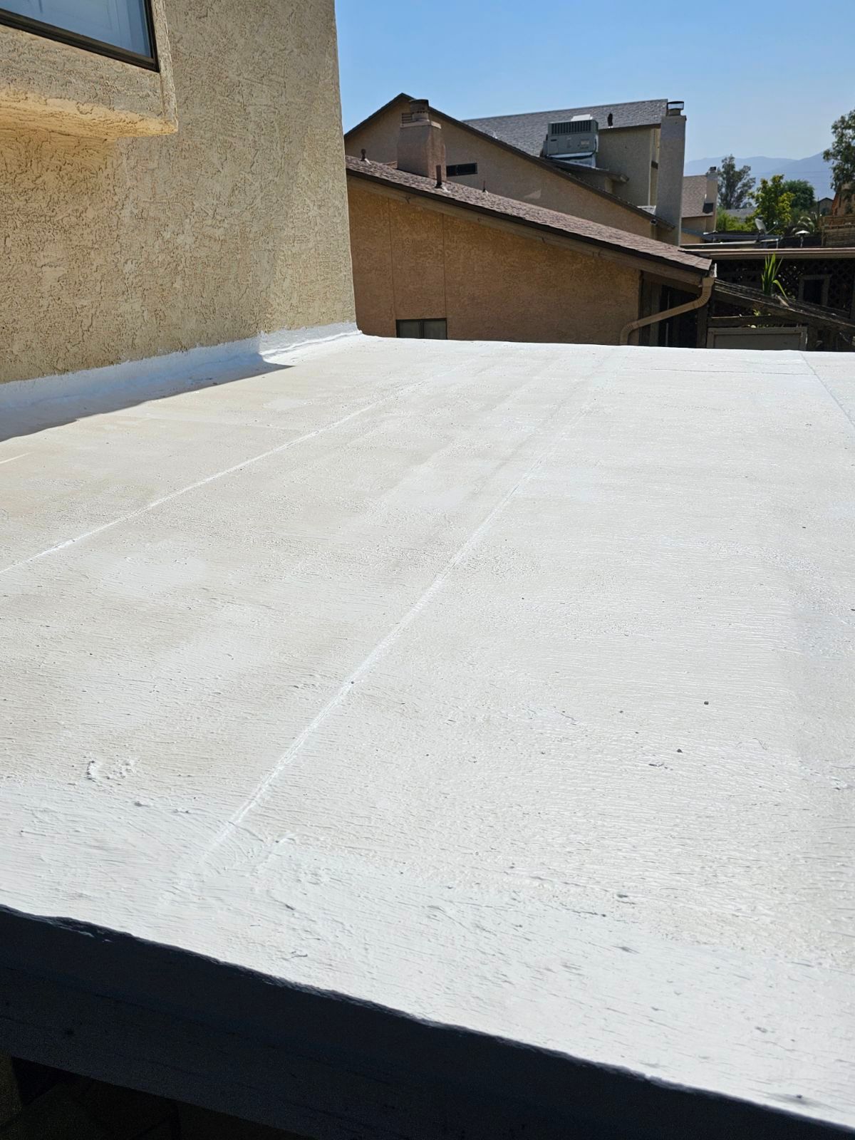A concrete roof with a building in the background