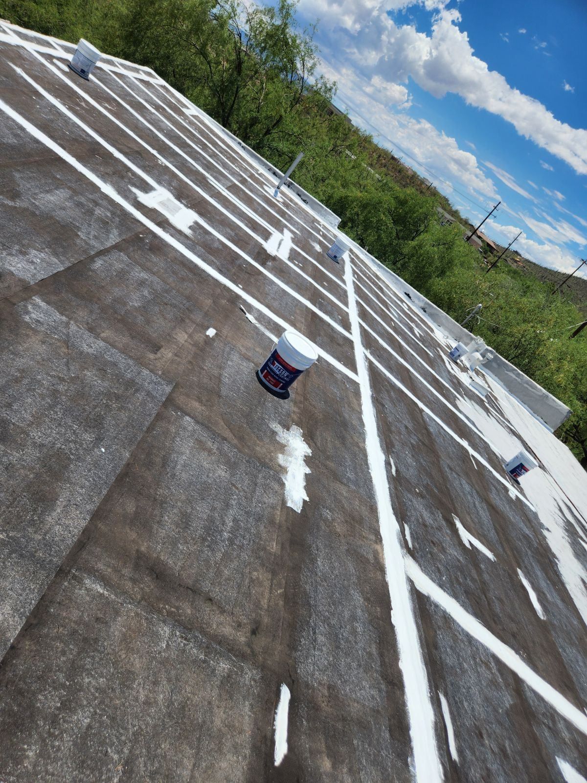 A roof with white lines on it is being painted.