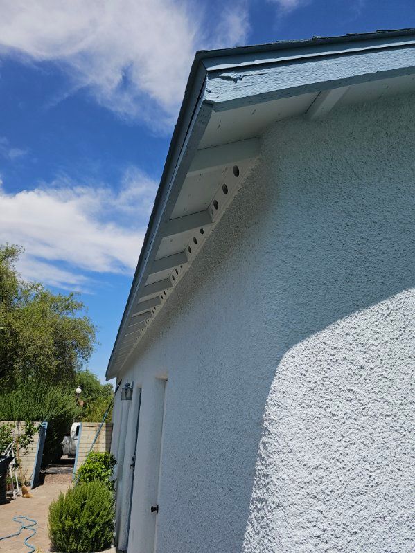 A white house with a blue roof and a blue sky in the background.