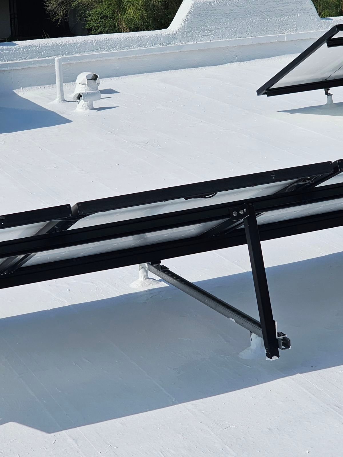 A solar panel is sitting on top of a white roof.