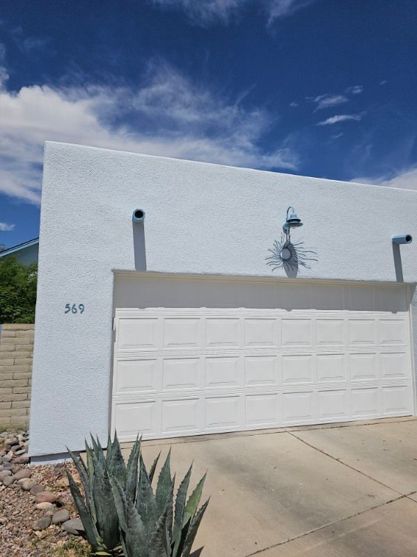A white garage door with a blue sky in the background.