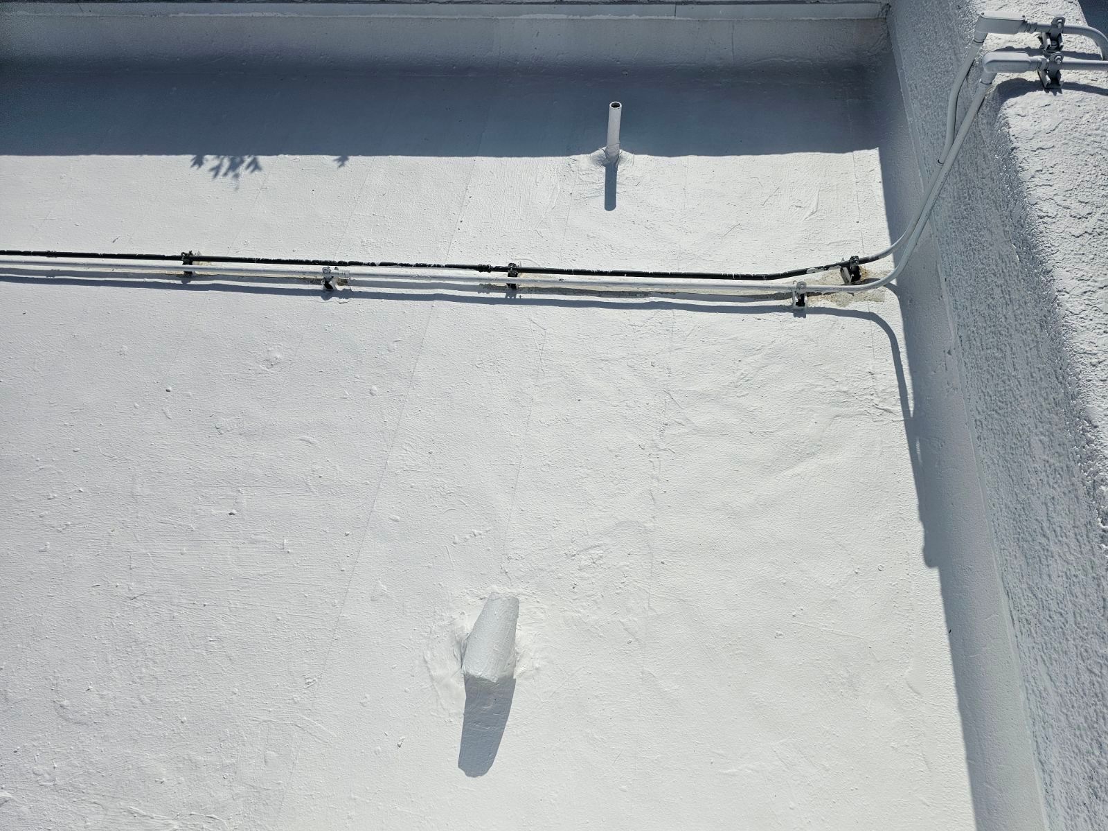 A white wall with a few wires on it