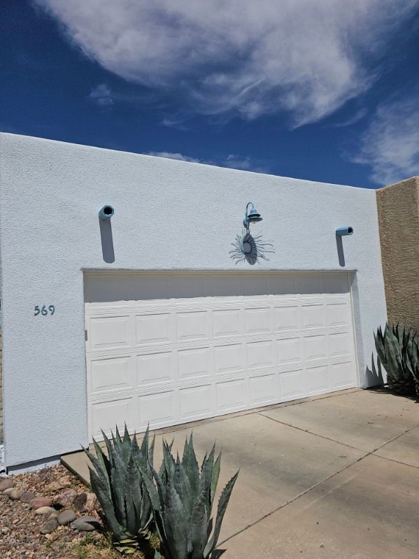 A white garage door is on the side of a house.