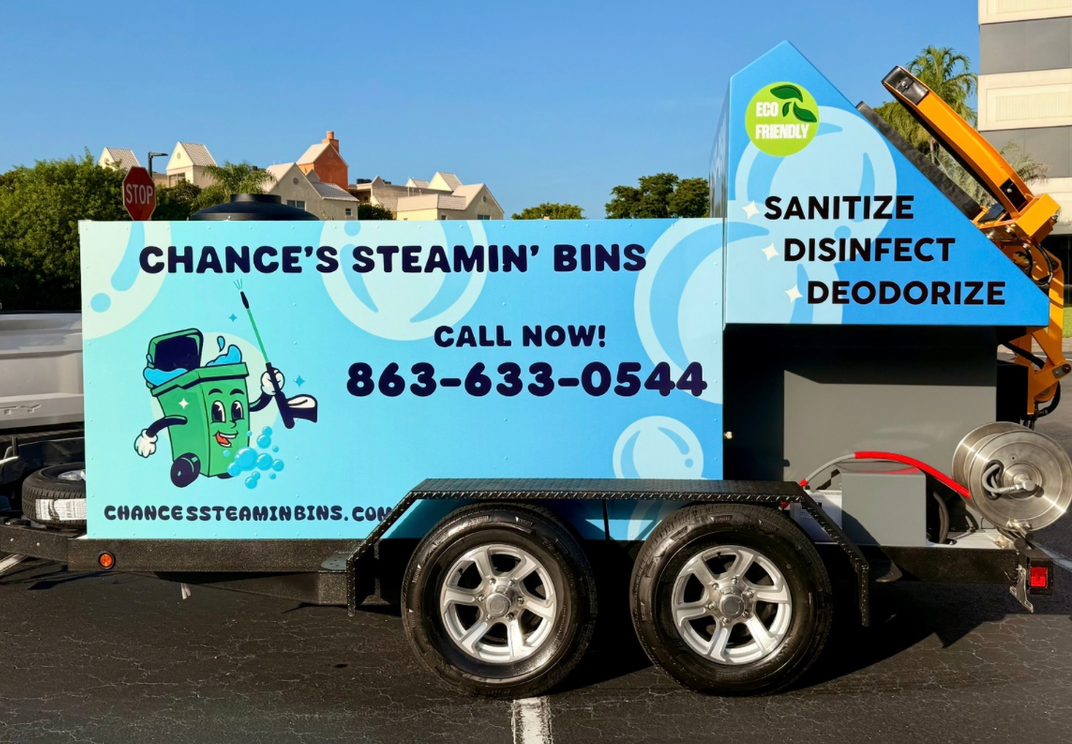 A green trash can with a piece of paper in it.