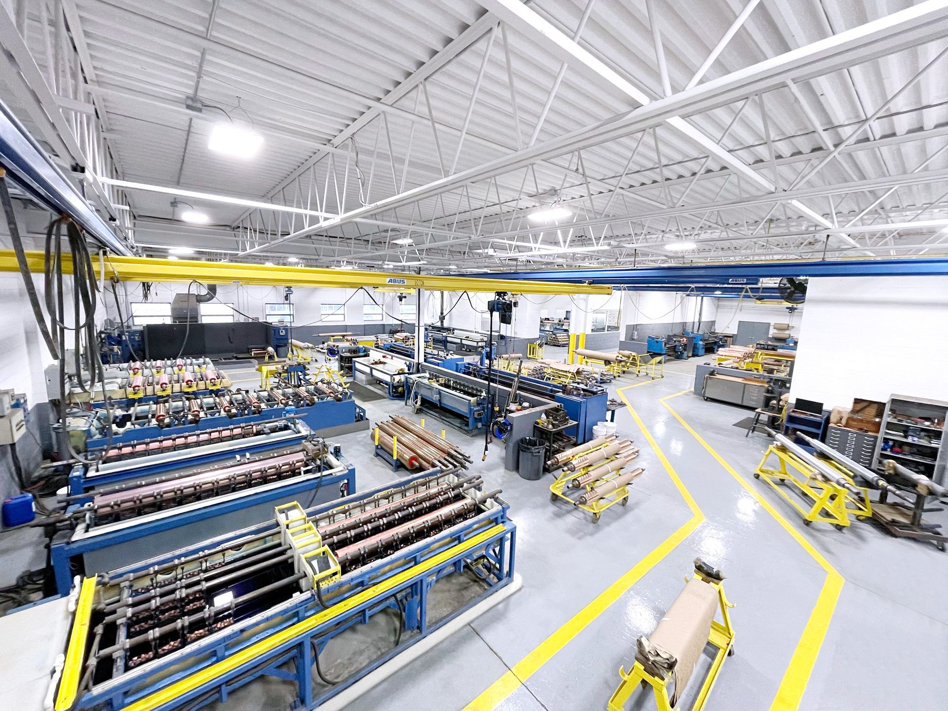 A factory filled with lots of machinery and lots of yellow lines.