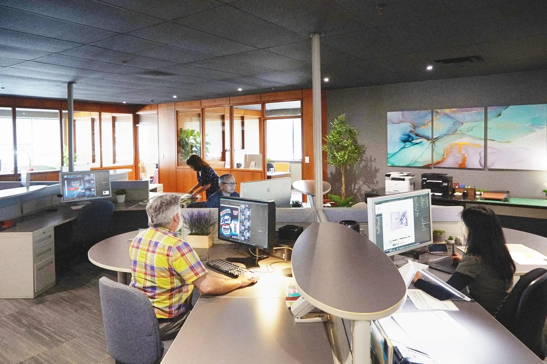 A man is sitting at a desk with a computer in an office