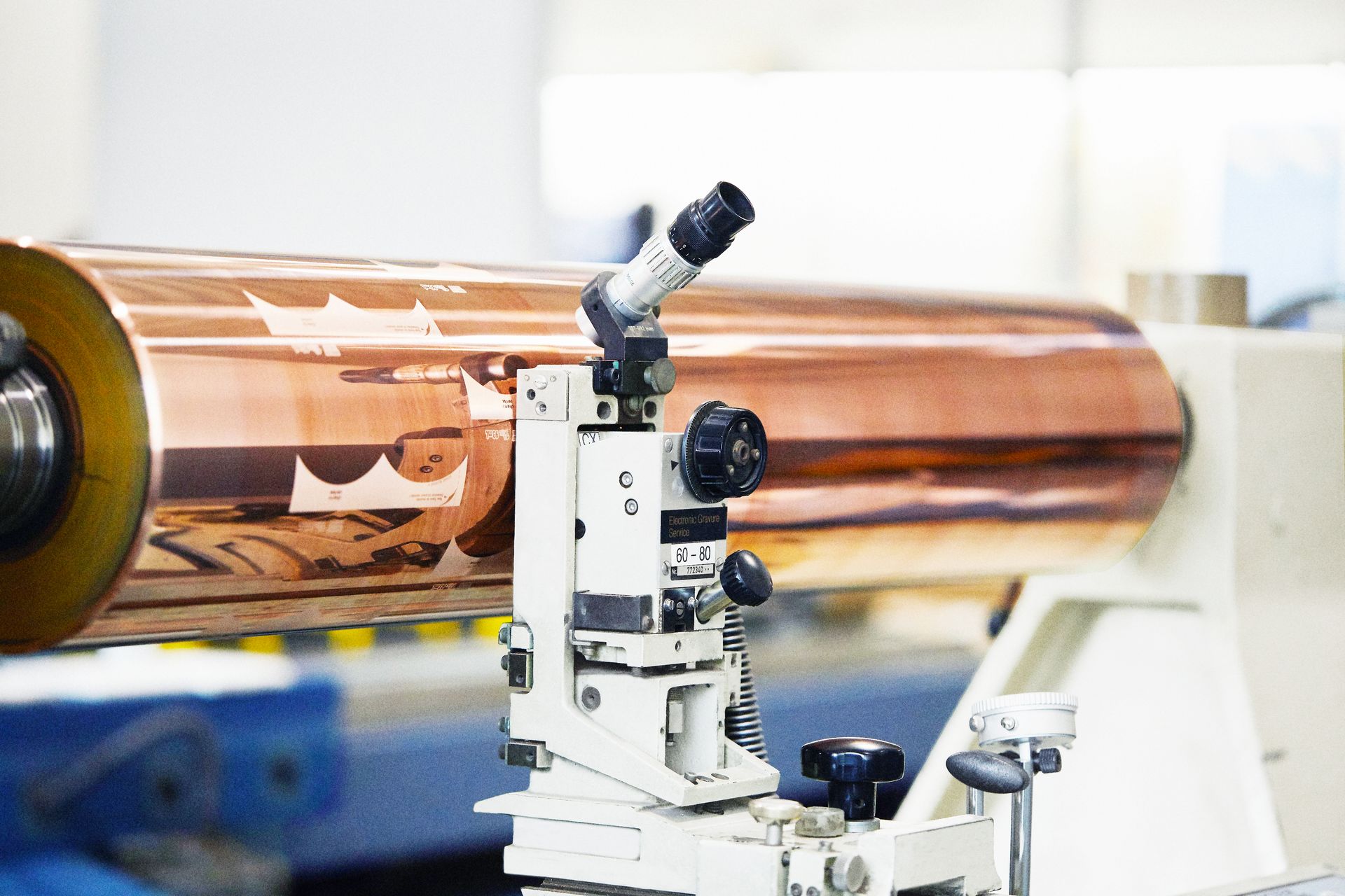 A close up of a machine with a microscope on it in a factory.