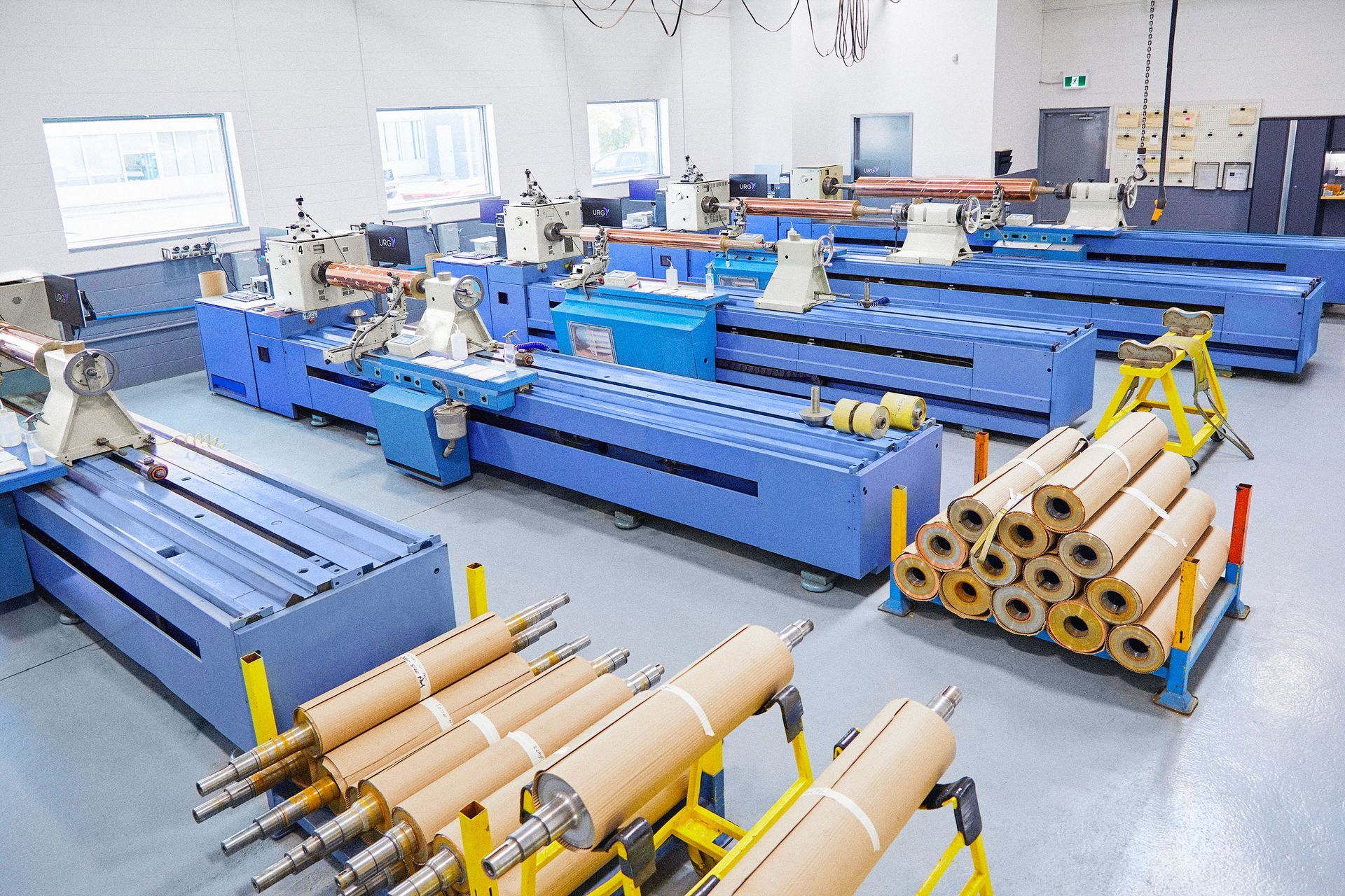 A factory filled with lots of machinery and rolls of paper.