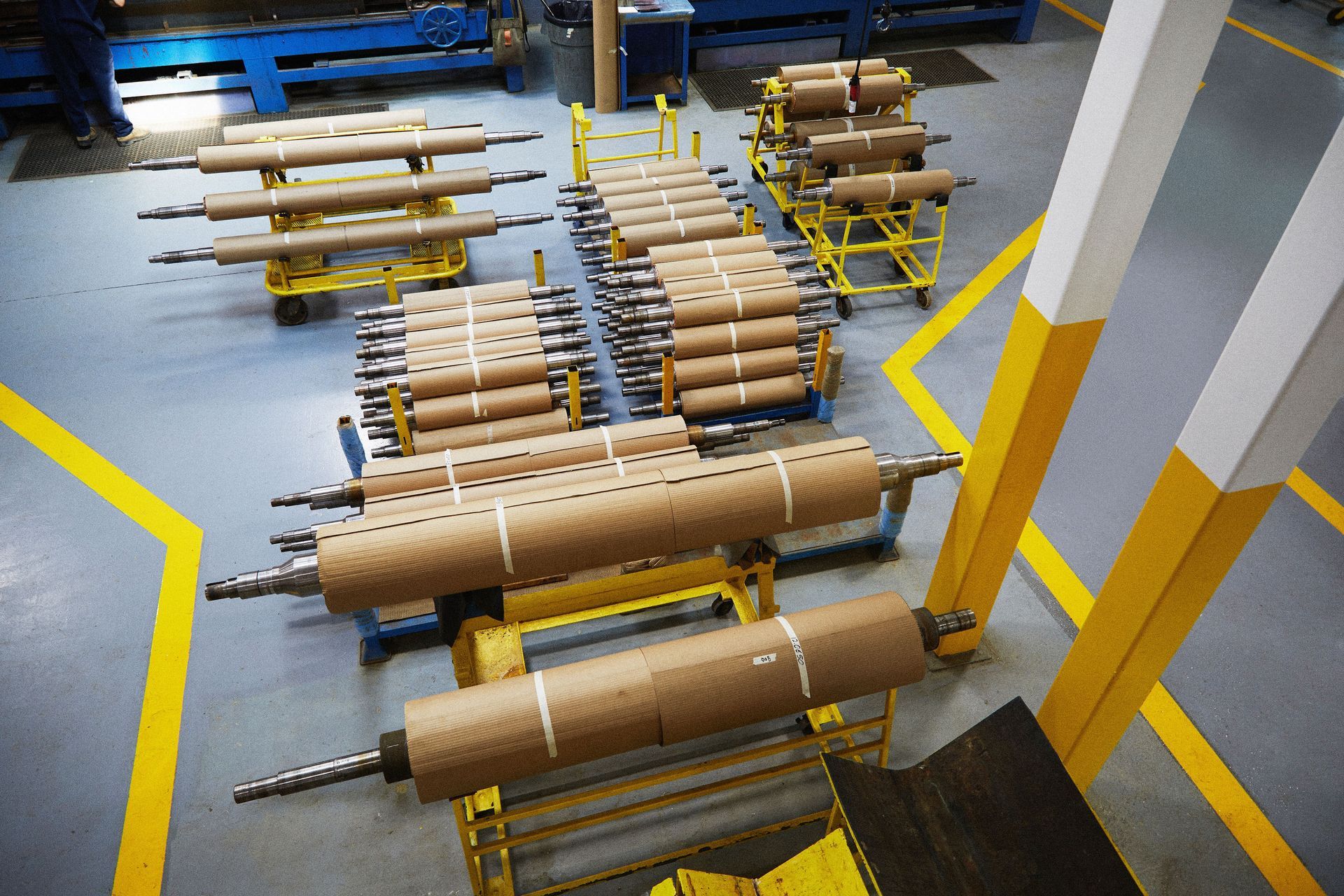 A bunch of rolls of paper are sitting on carts in a factory