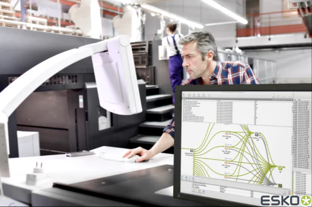 A man is looking at a computer screen in a factory.