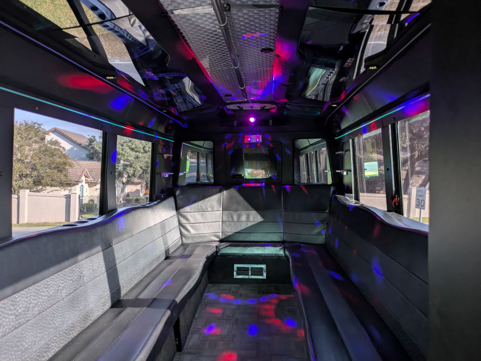 Blue Line San Antonio Party Bus Up to 16 passengers nighttime inside lights on view parked in Leon Springs