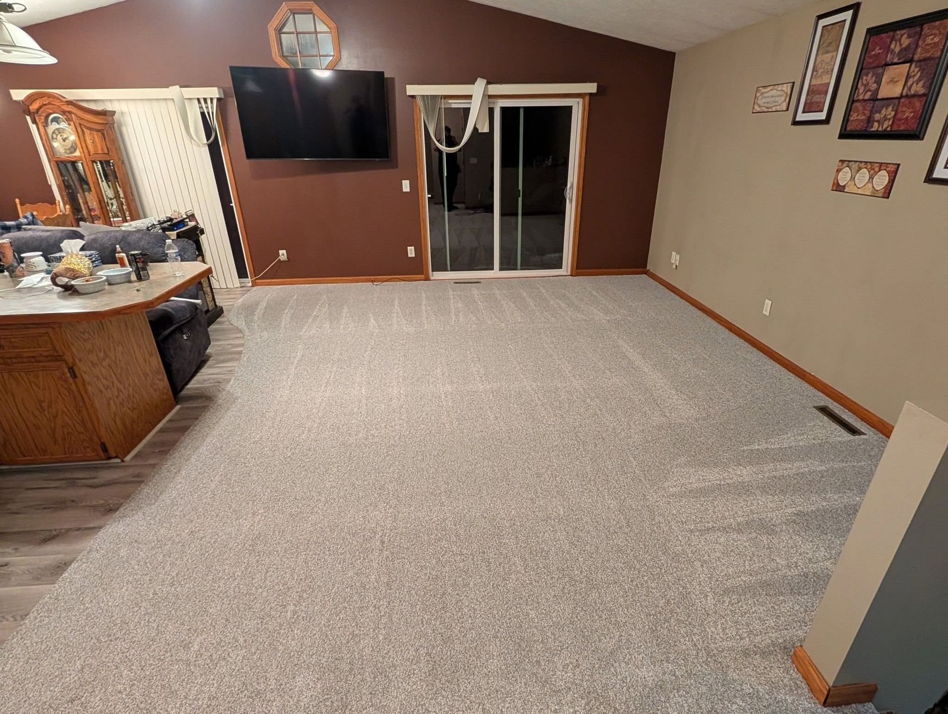 A living room with a sliding glass door and a flat screen tv.