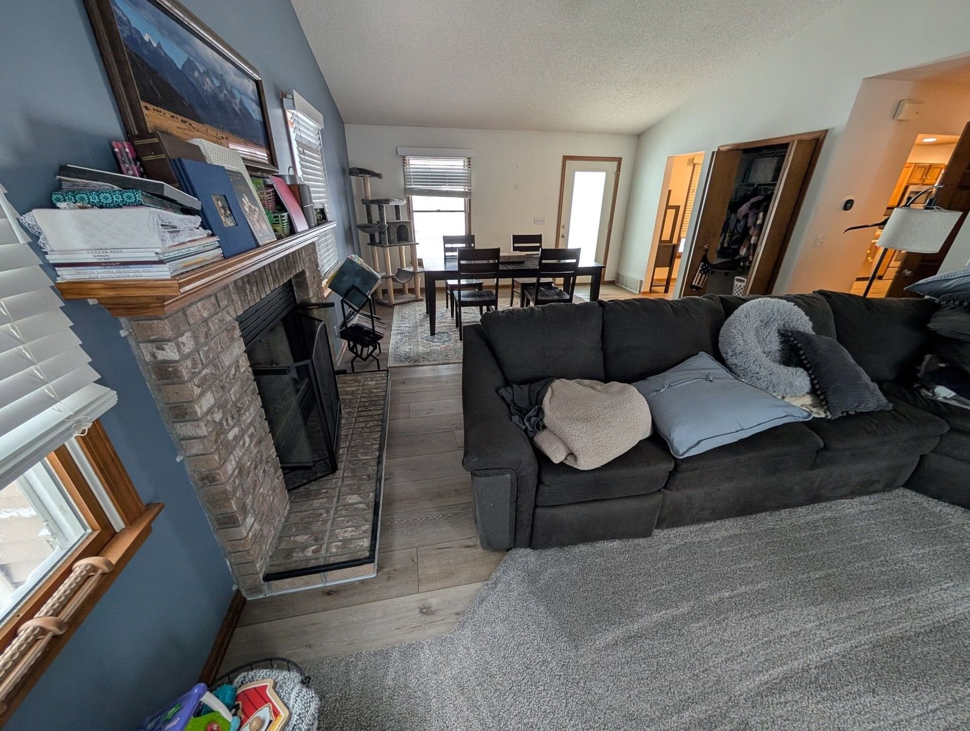 A living room with a couch , fireplace , table and chairs.