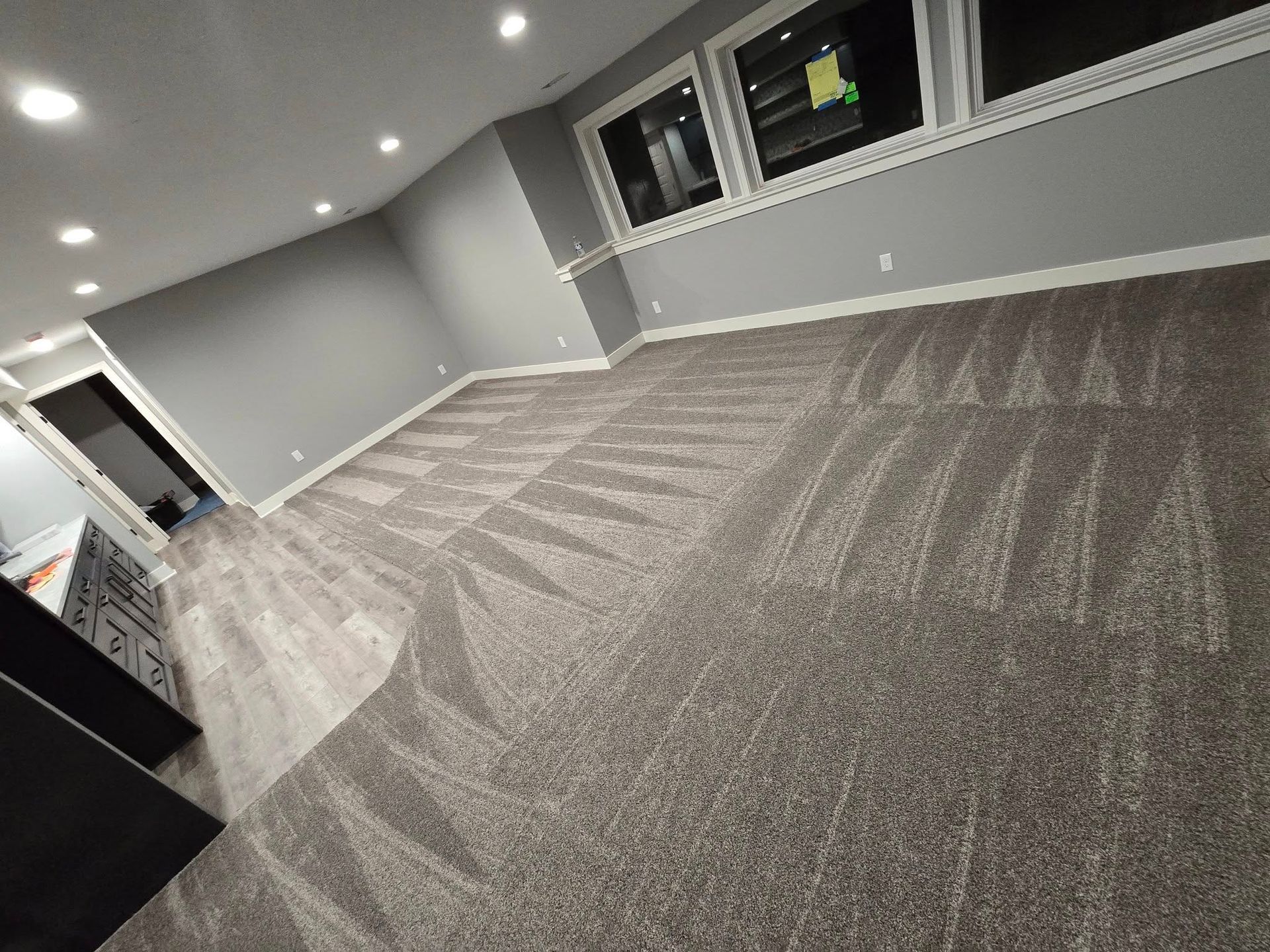 A room with a lot of windows and a carpeted floor.