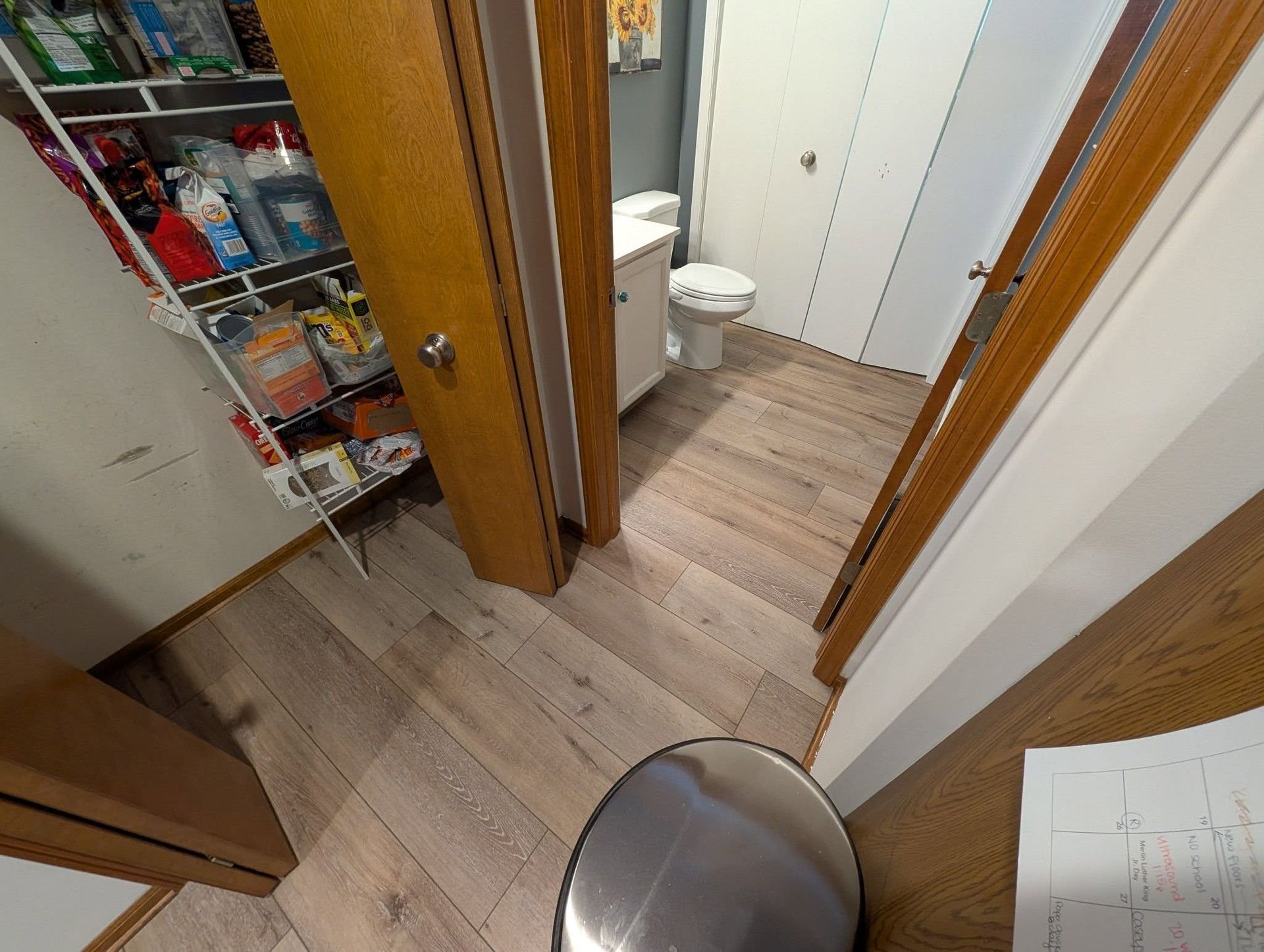 A bathroom with a toilet , sink , and pantry.