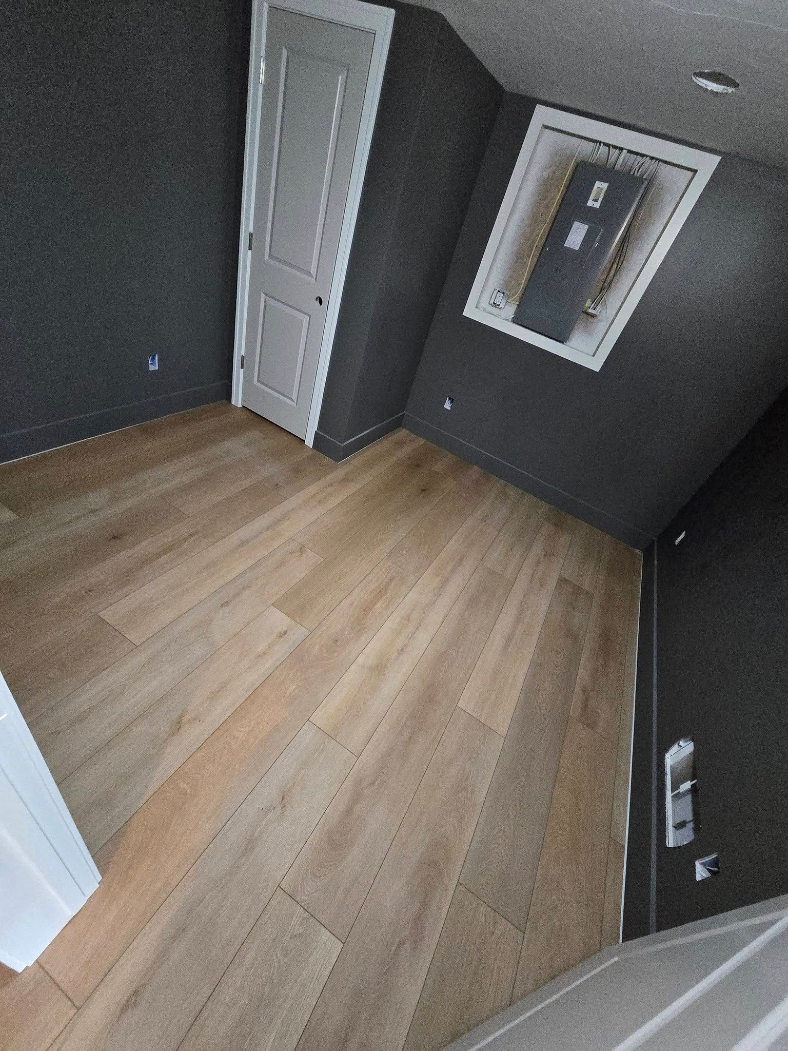 A room with a wooden floor and a window on the ceiling.