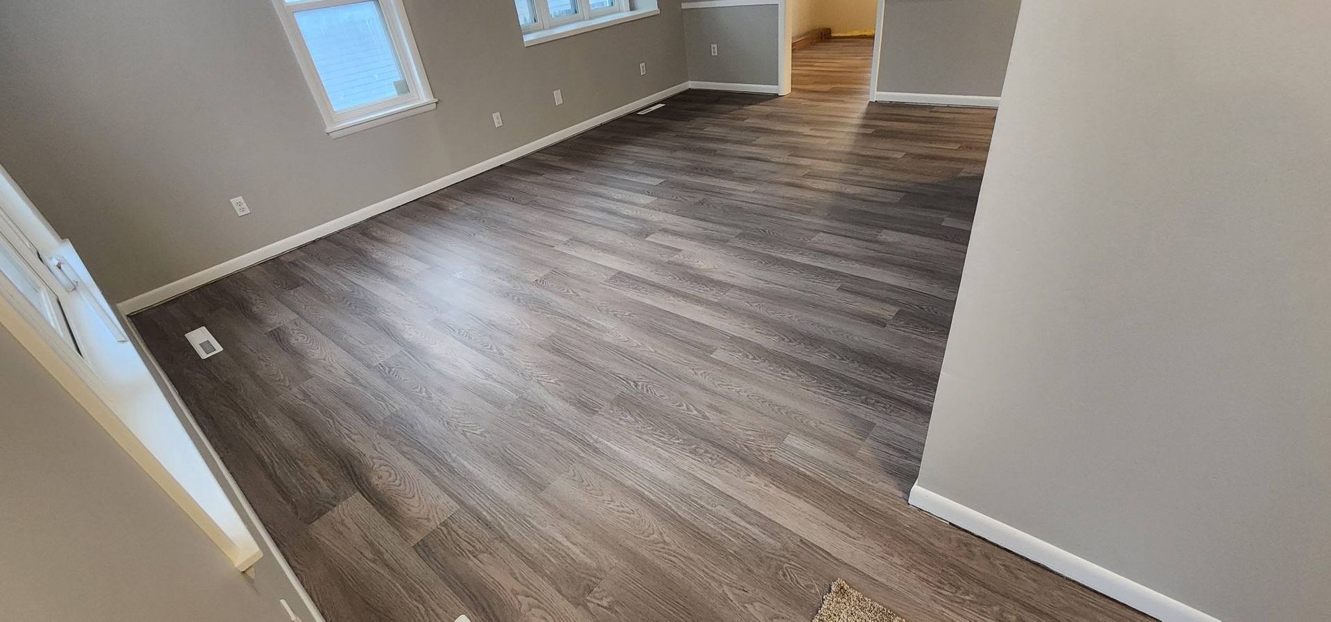 A living room with a wooden floor and a window.