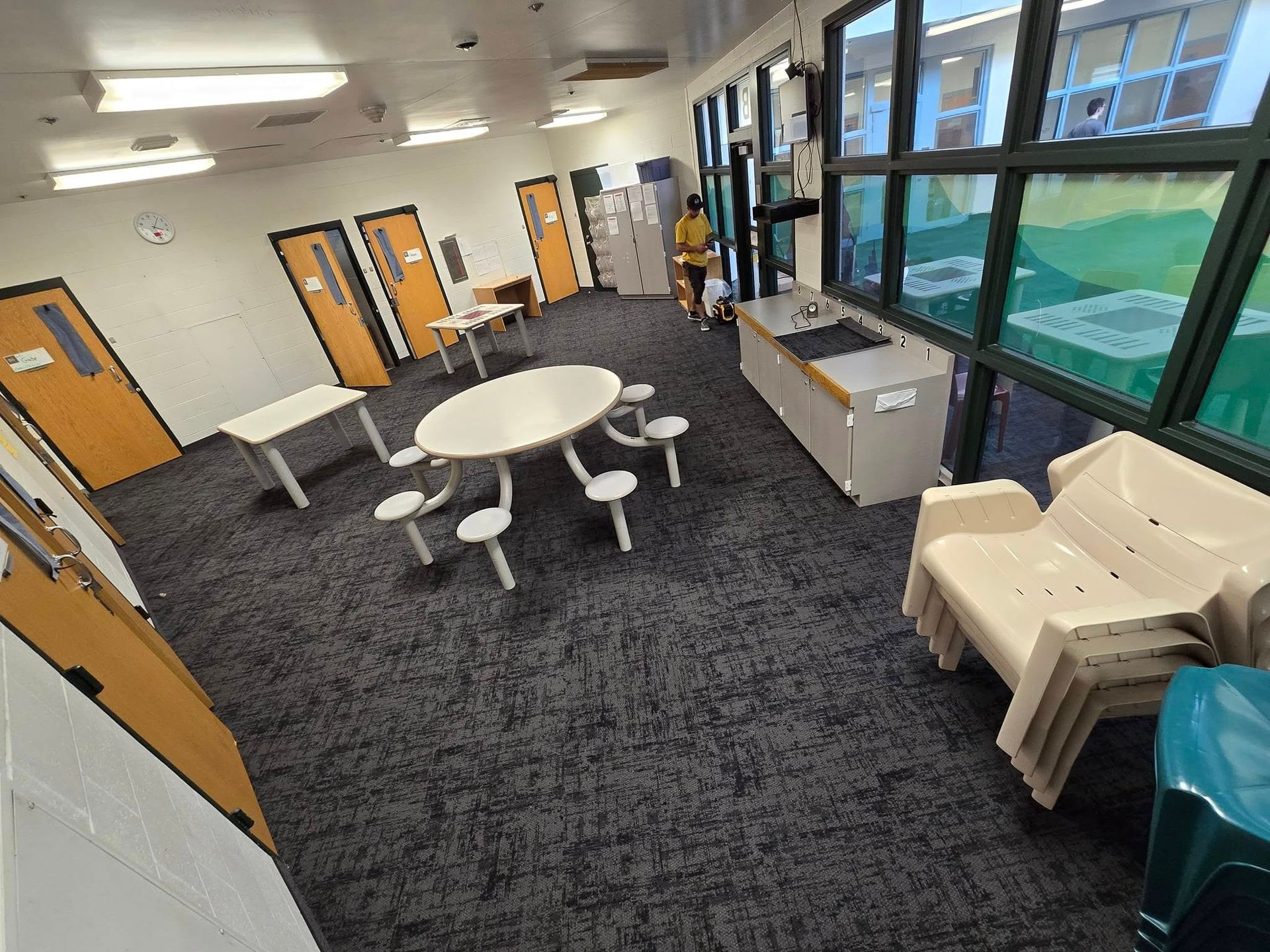 A large room with a table and chairs in it.