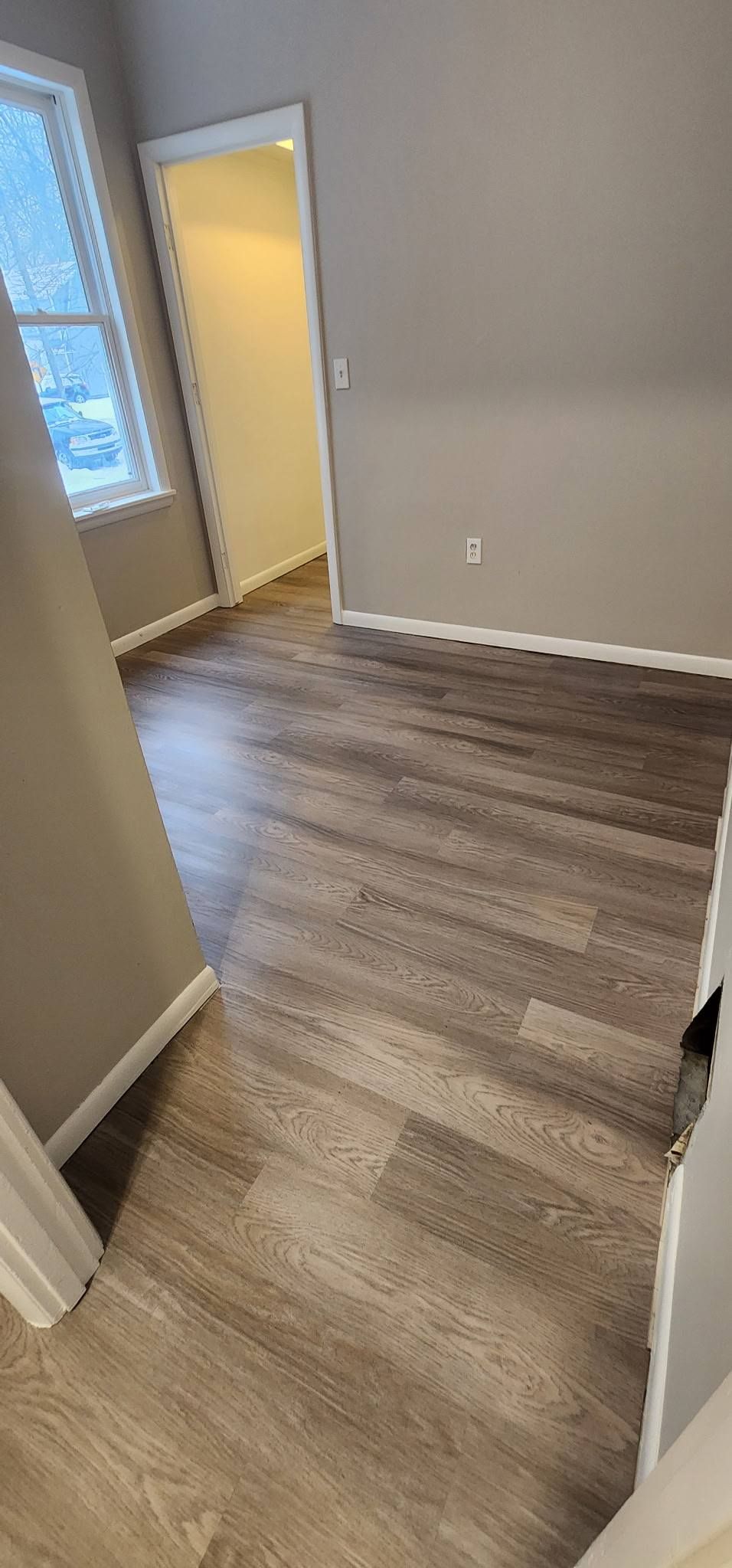 A room with hardwood floors and a window.