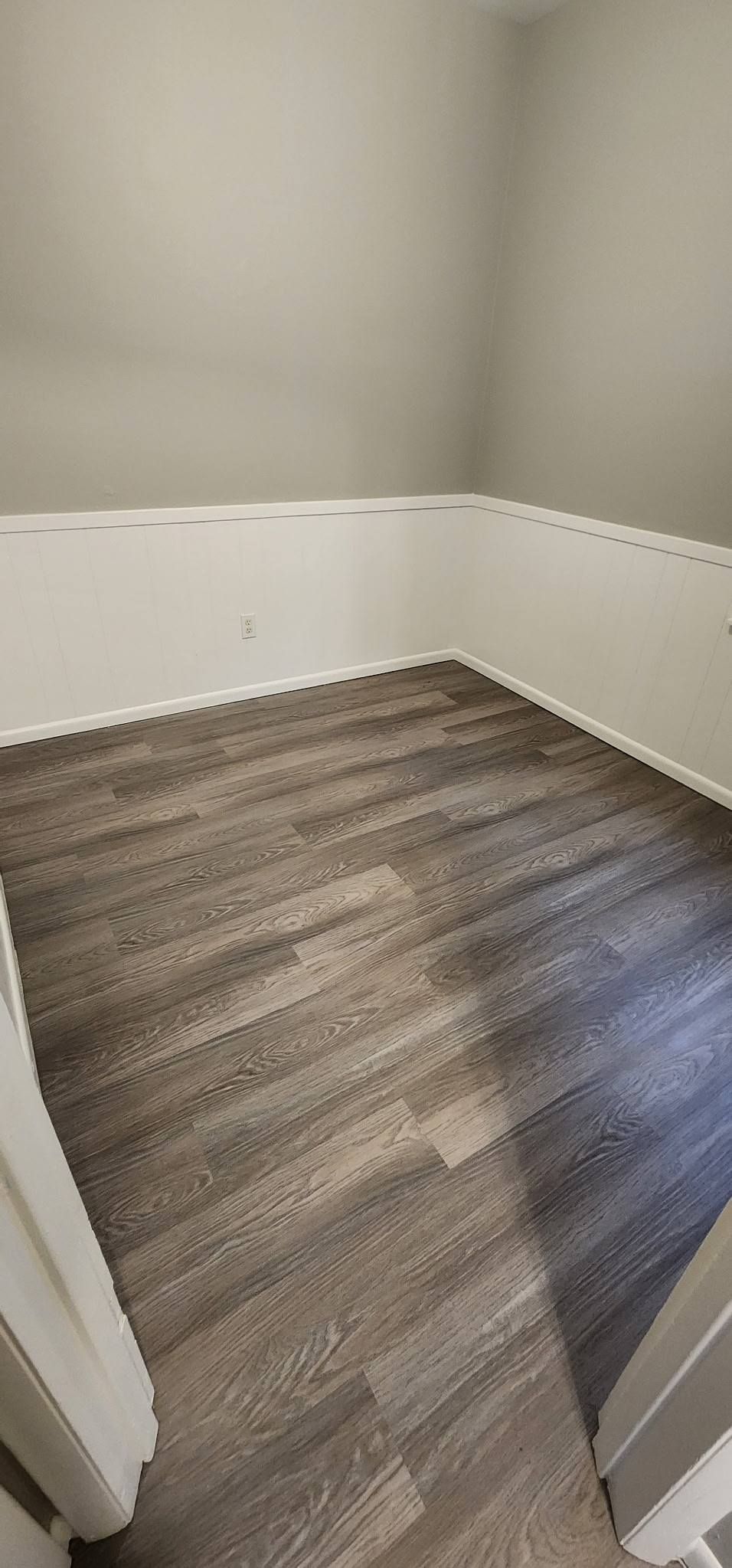 A room with a wooden floor and white walls.
