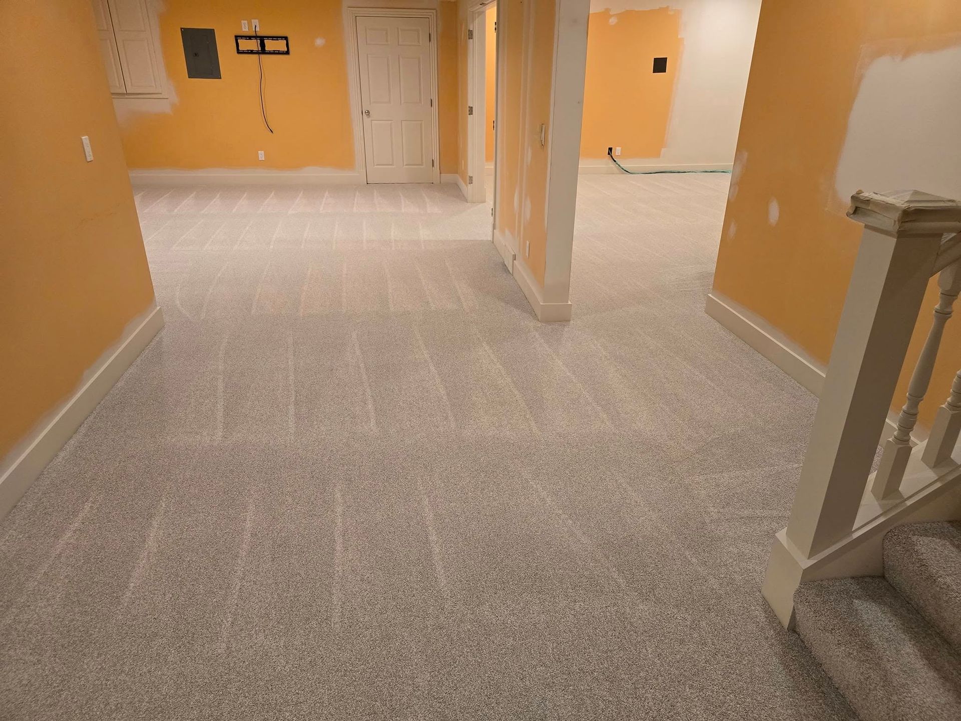 An empty basement with a staircase leading up to the second floor.