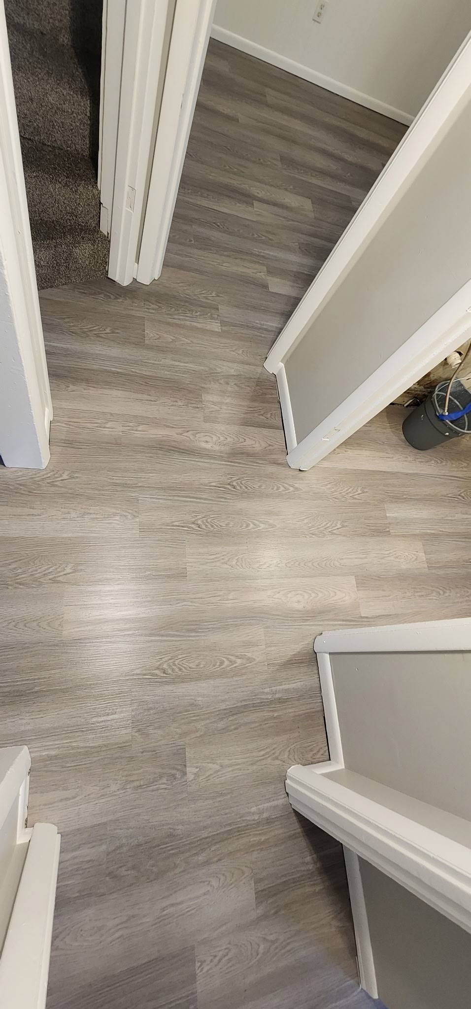 A hallway with hardwood floors and stairs in a house.