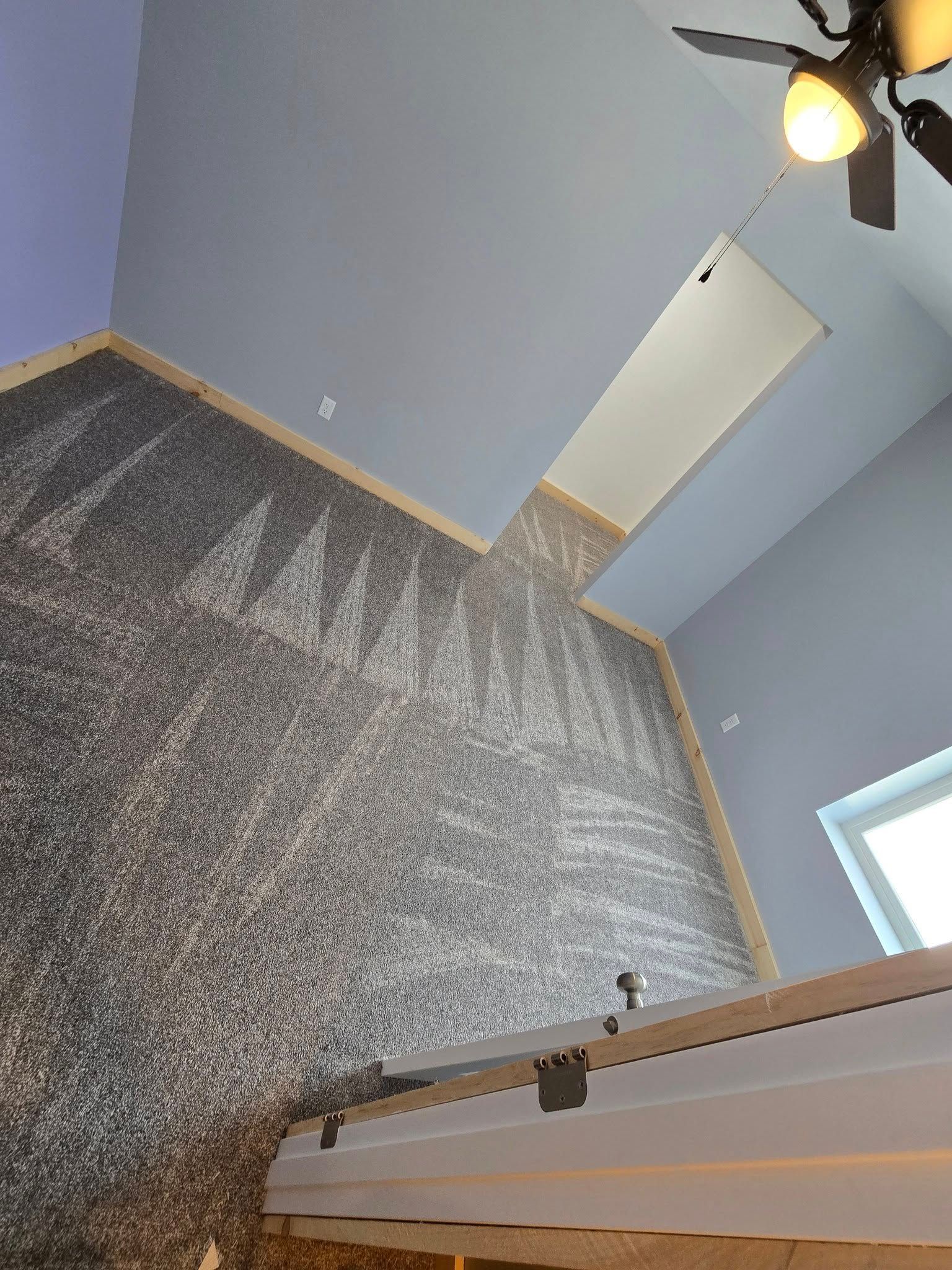 A ceiling fan is hanging from the ceiling of a room.