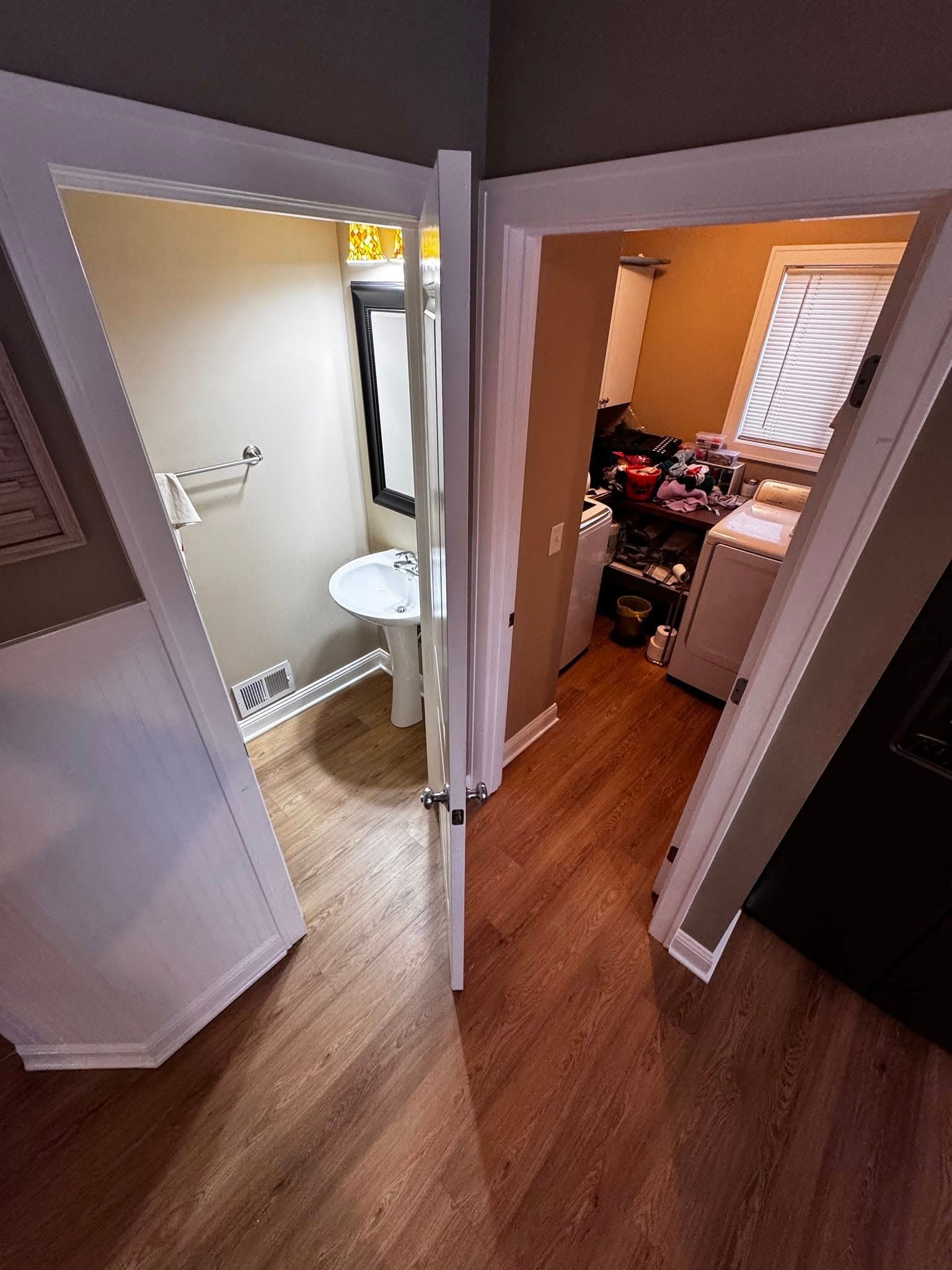 A bathroom with a sink and a washer and dryer in a house.
