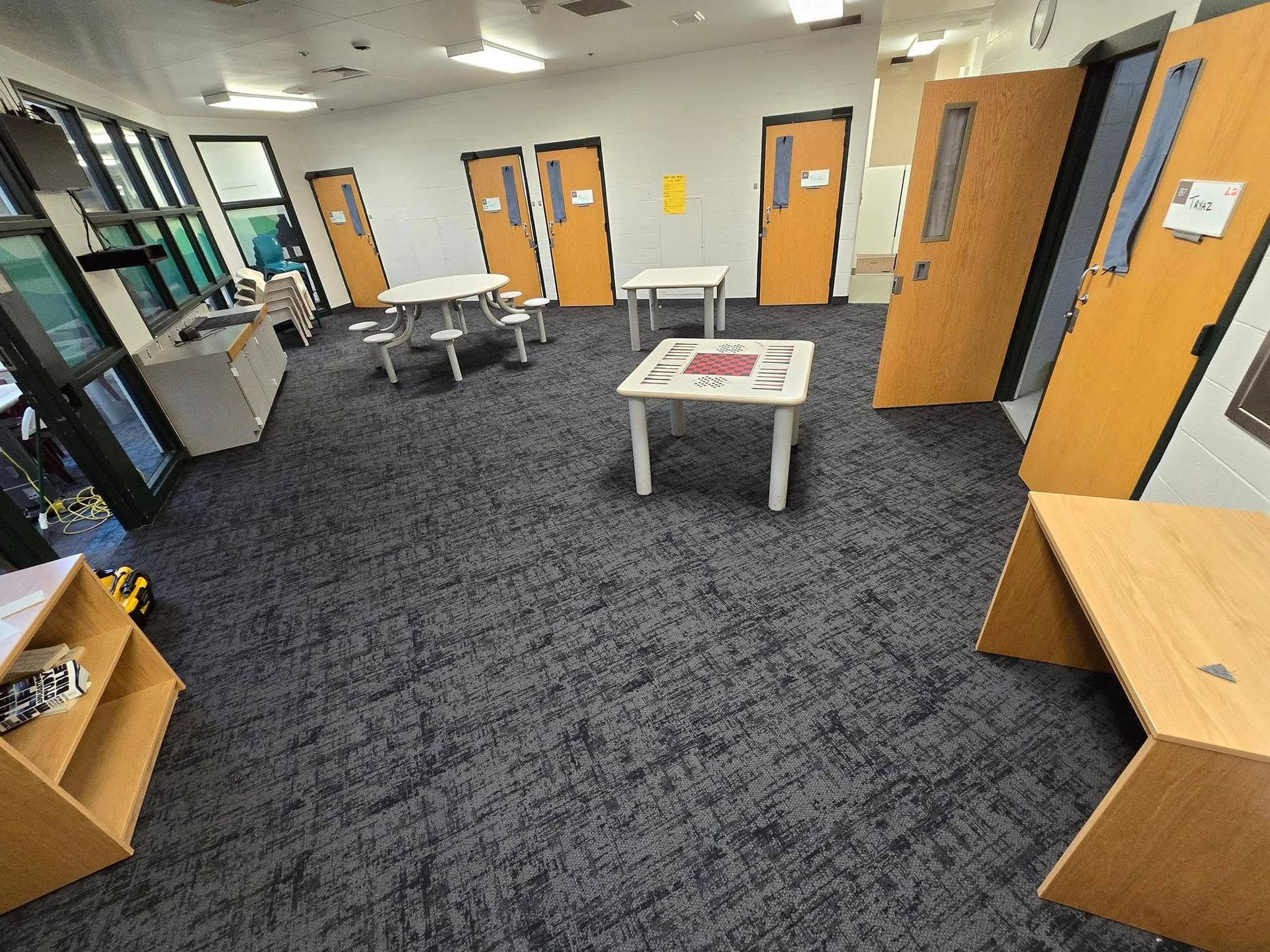 A large room with a lot of doors and tables.