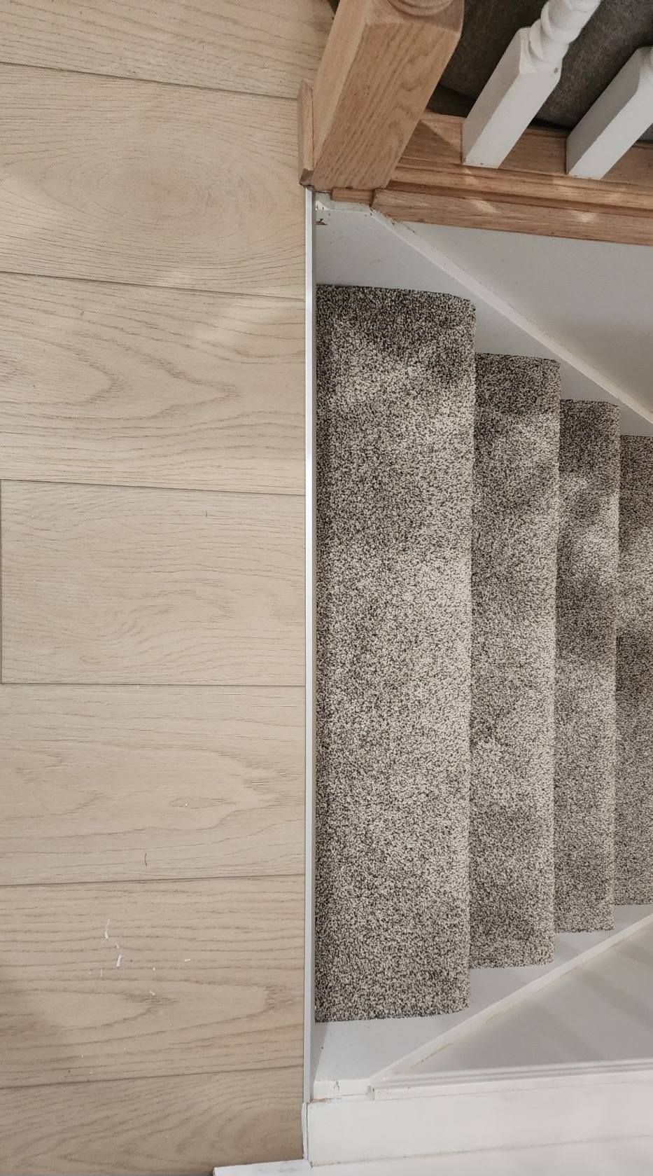 A close up of a wooden staircase with a carpeted staircase.