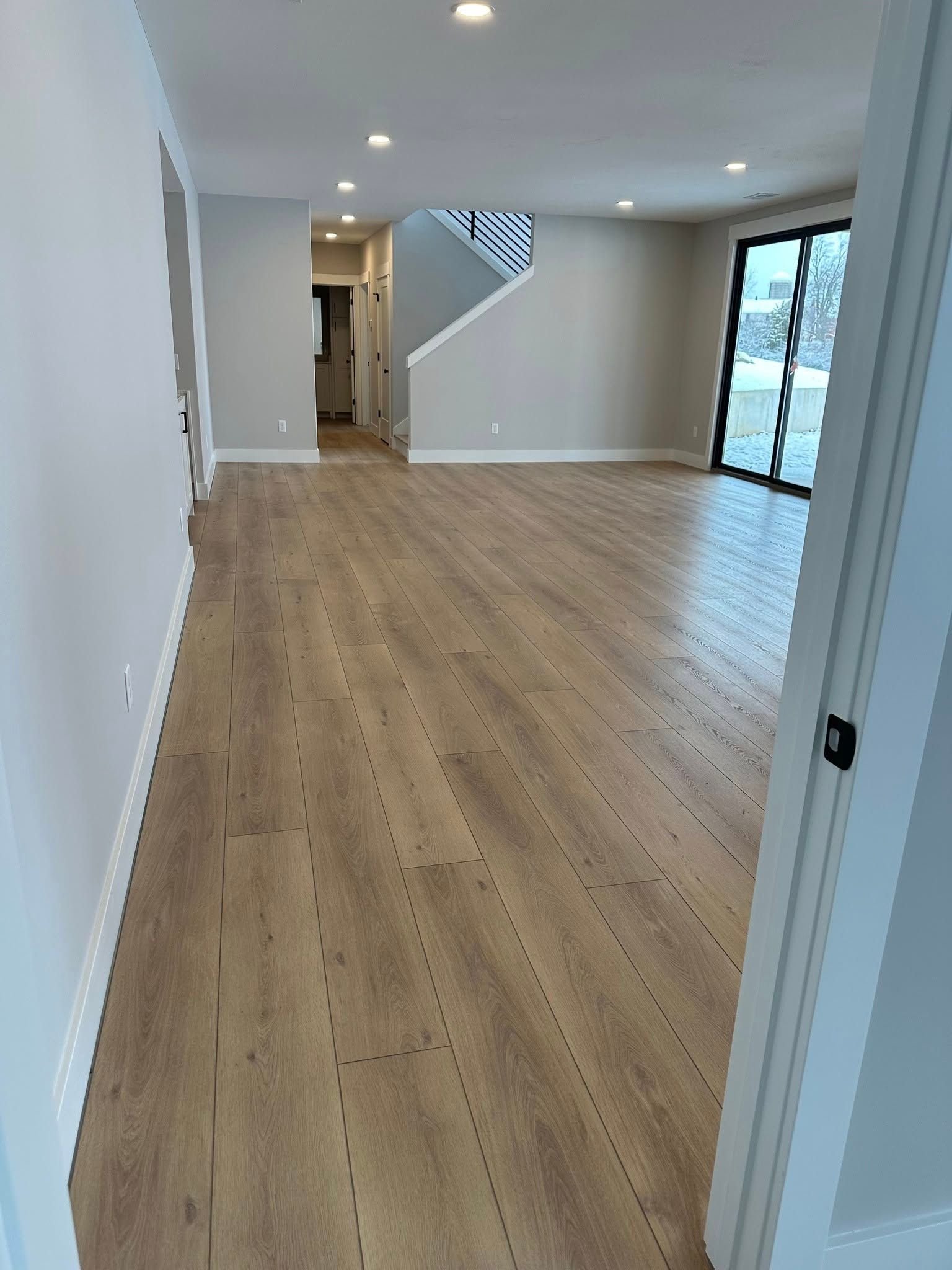 A large empty room with hardwood floors and white walls.