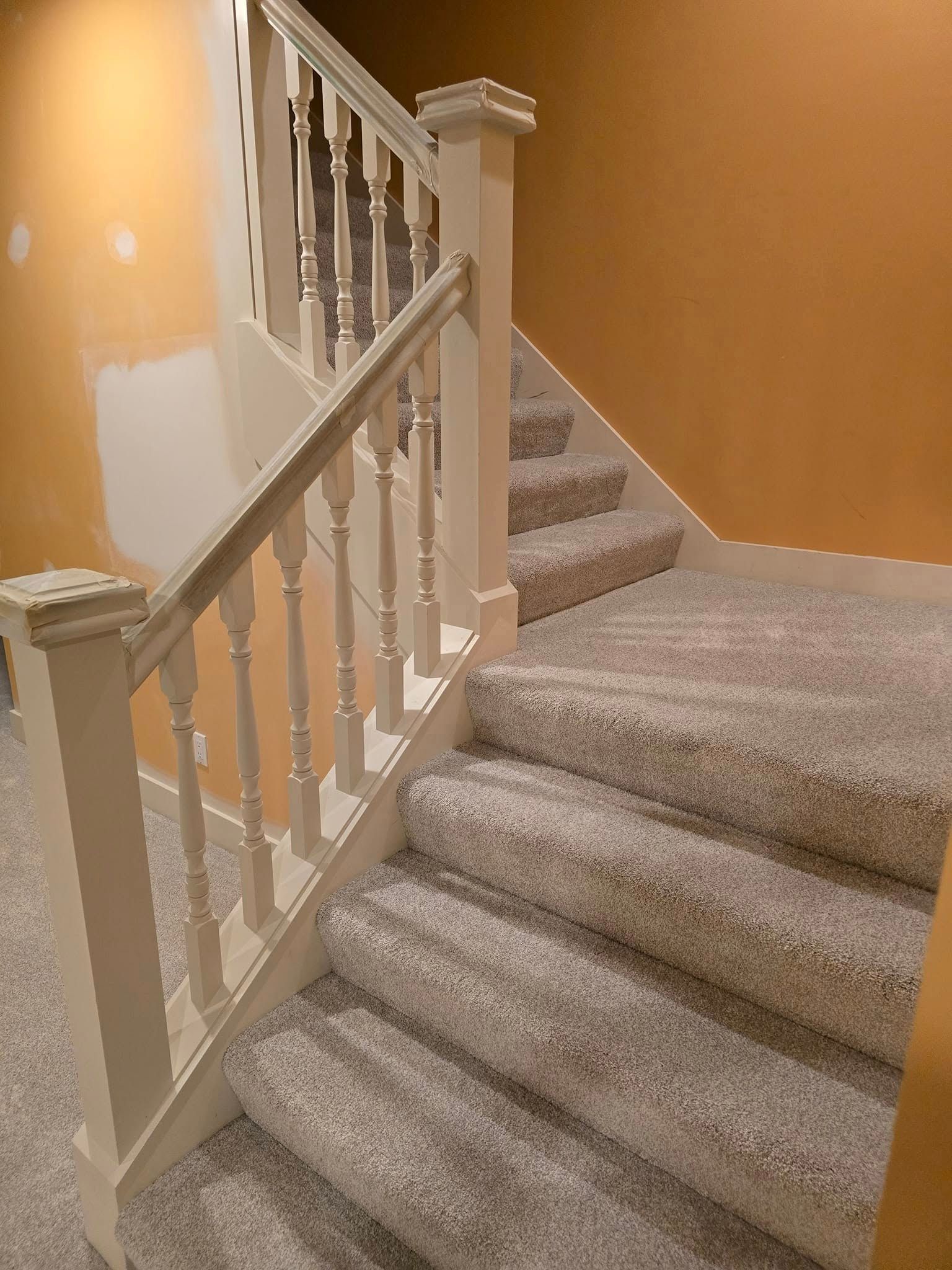 A staircase with carpeted steps and a white railing.