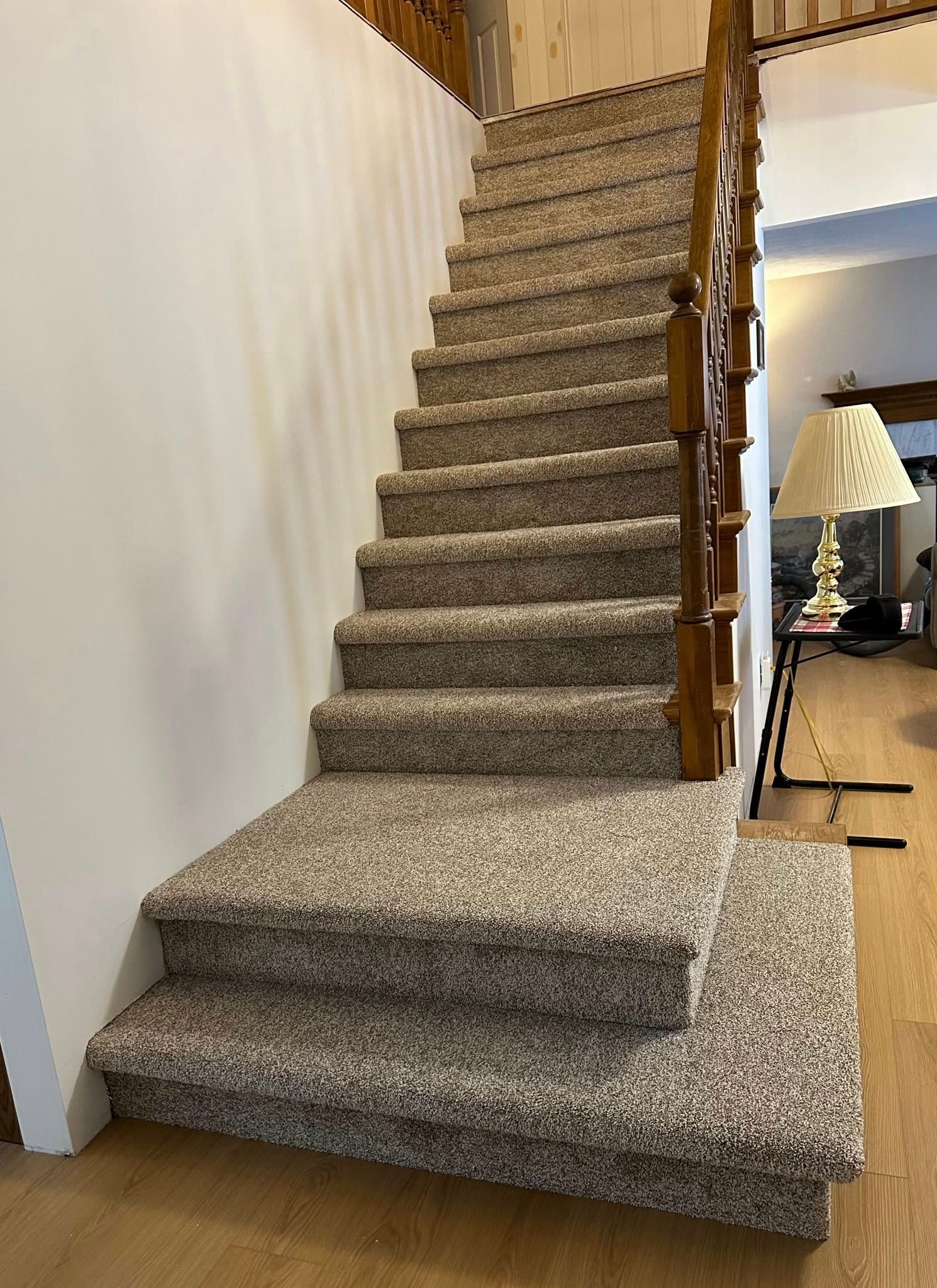A staircase with carpeted steps and a wooden railing in a living room.