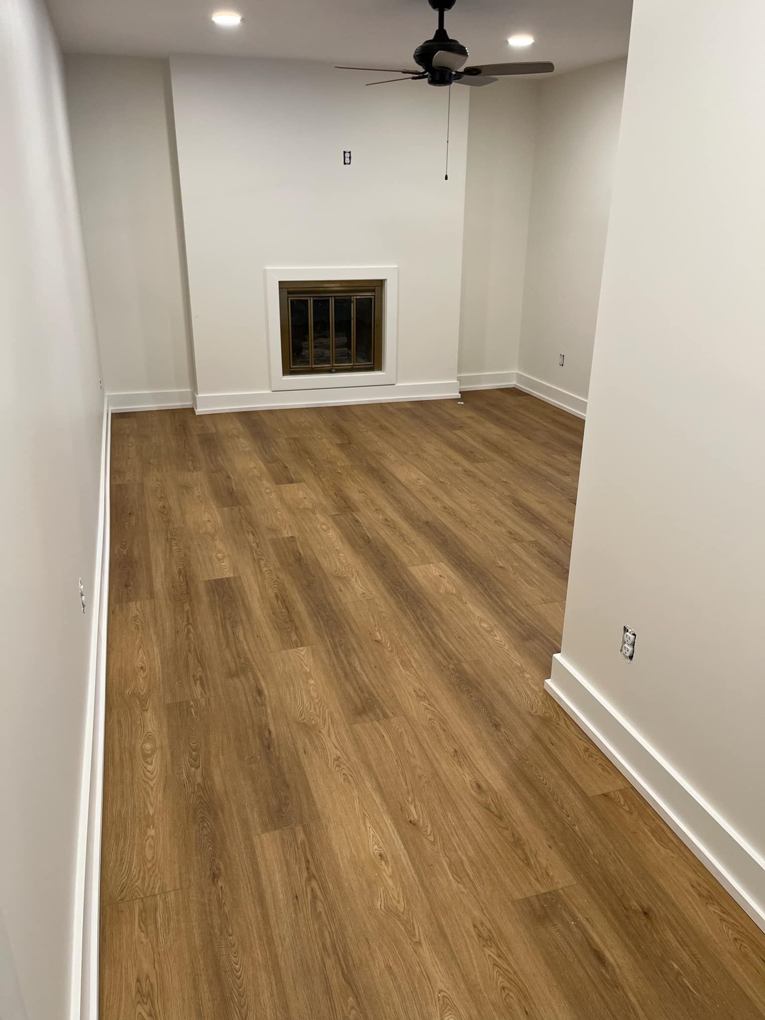 A living room with hardwood floors and a fireplace.