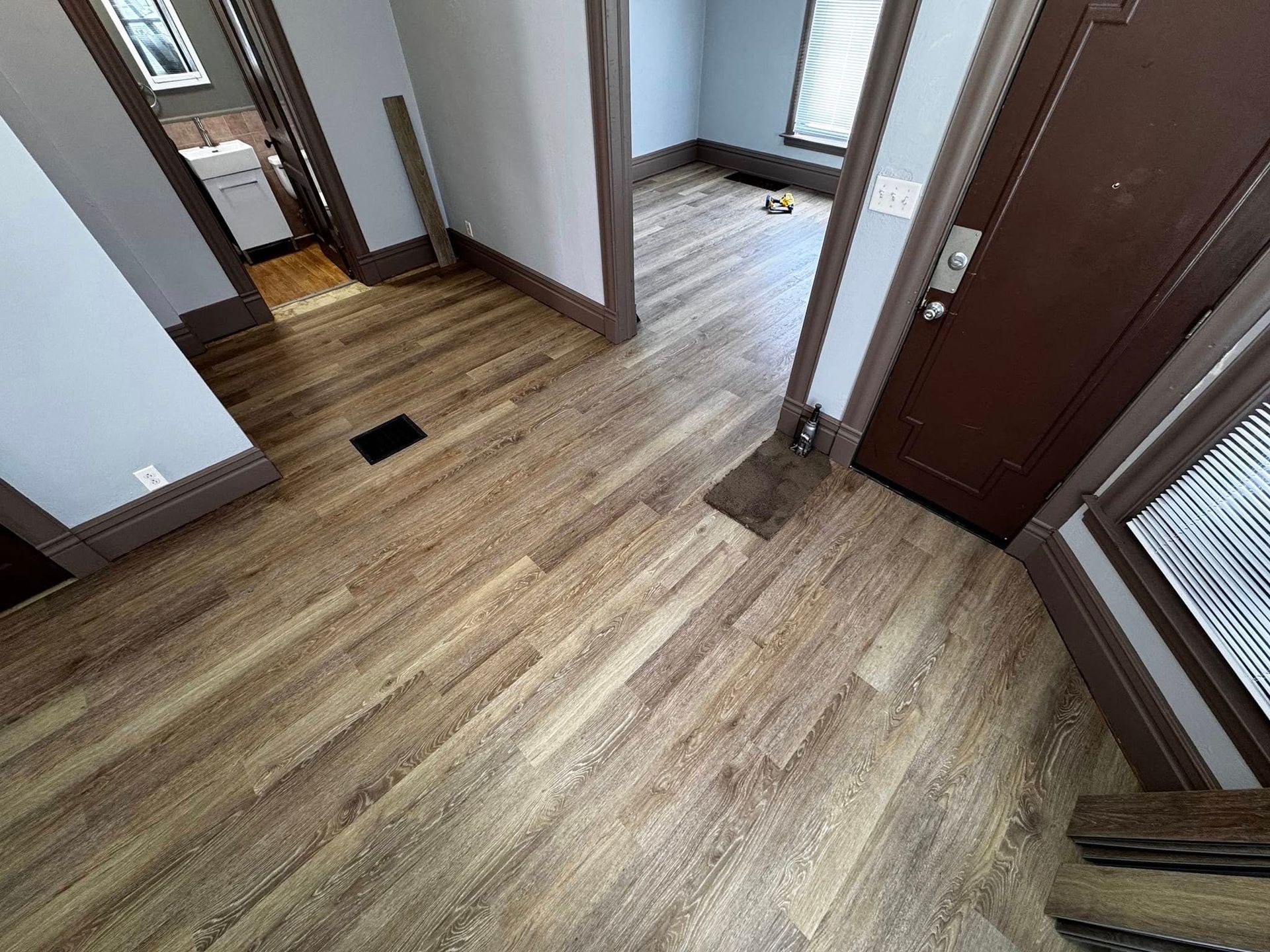 A hallway with hardwood floors and a door in a house.