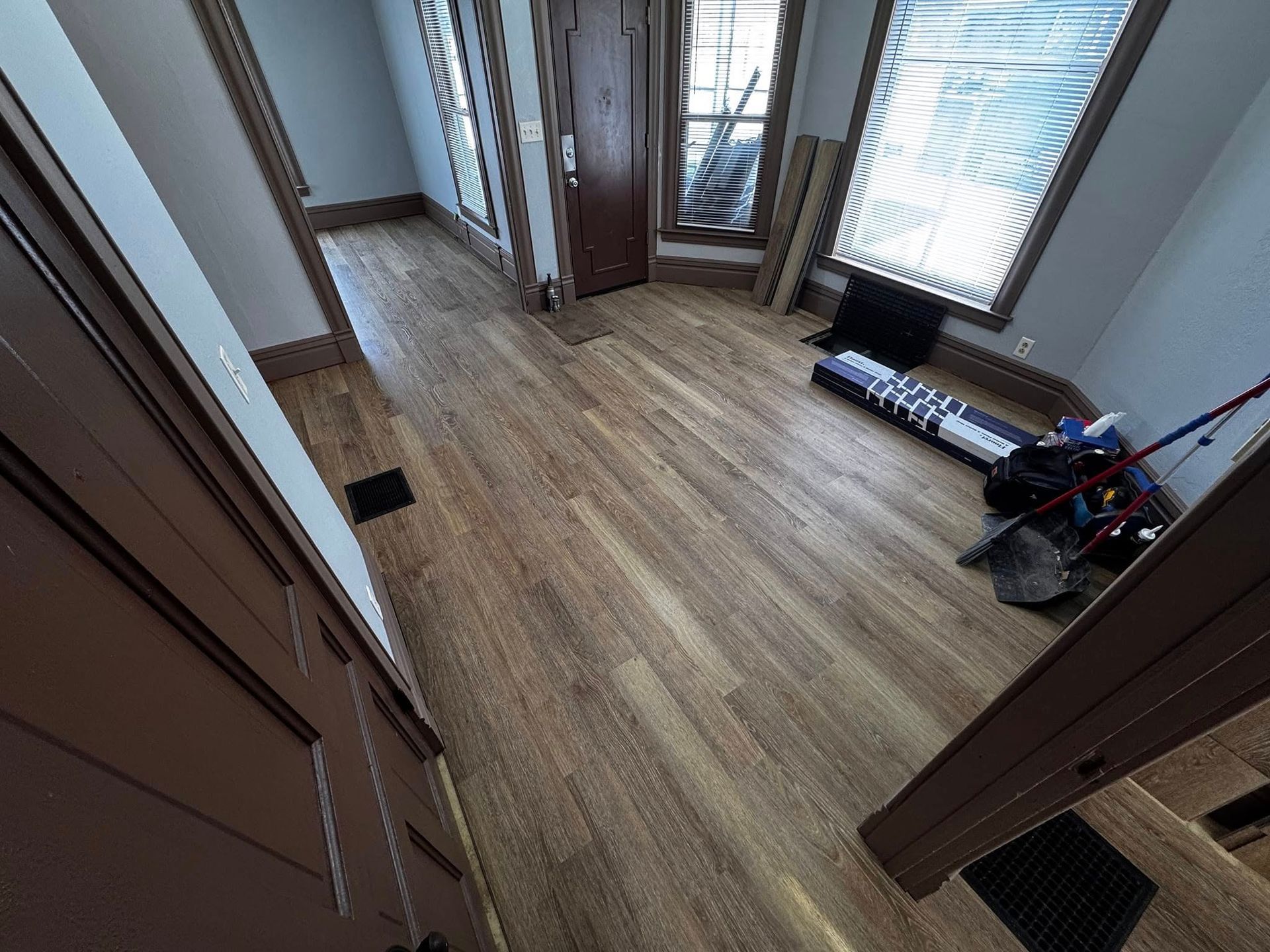 A hallway with hardwood floors and a window.
