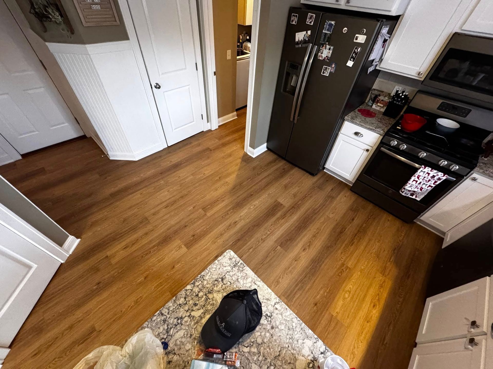 A kitchen with hardwood floors and a black refrigerator